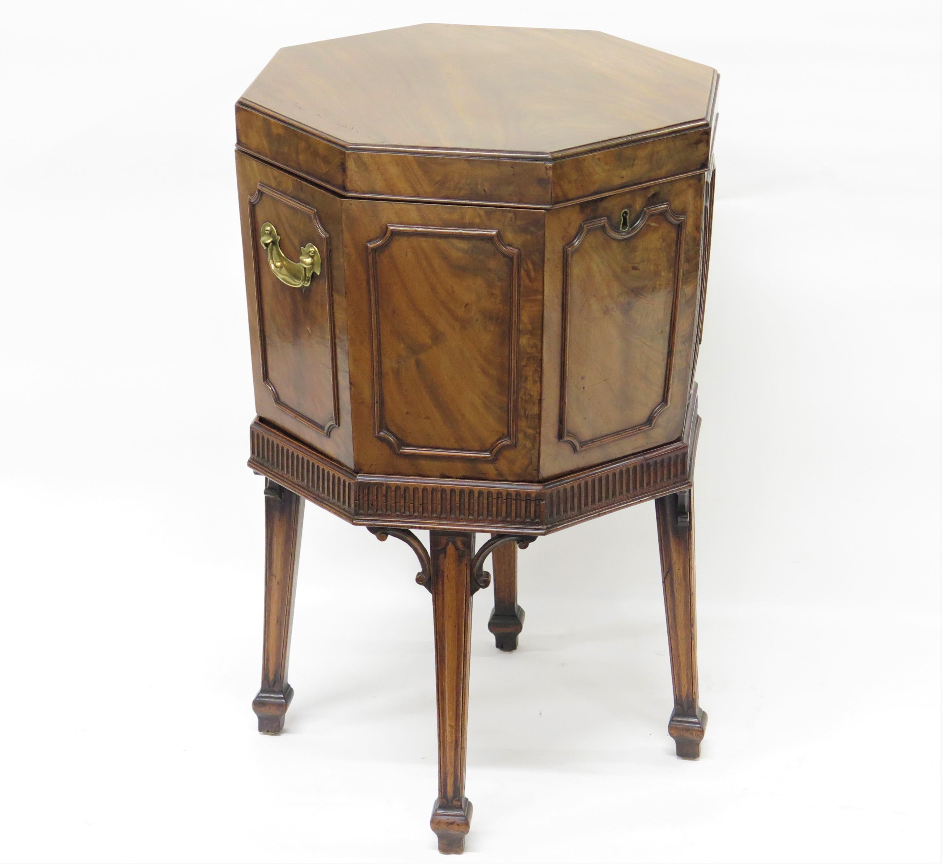 an octagonal George III mahogany cellarette on stand, beautifully figured mahogany sides with molding / trim panels, brass bail handles each side, rests on stand with four (4) tapered legs each having 
