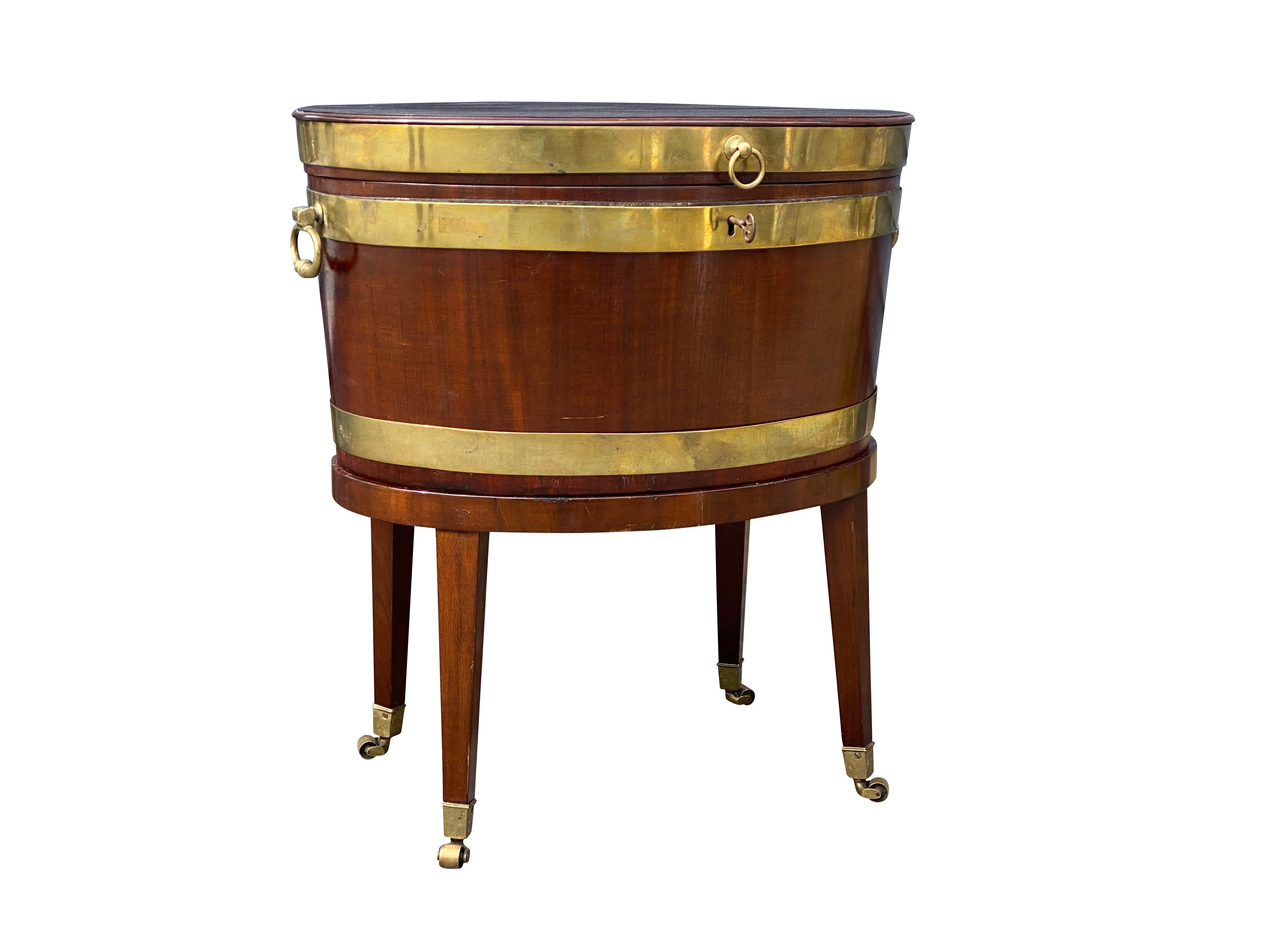 Le plateau ovale à charnière est surmonté d'un coffret conforme en laiton avec poignées en laiton, le tout reposant sur des pieds coniques carrés avec roulettes. Ex Naill Smith Antiques.