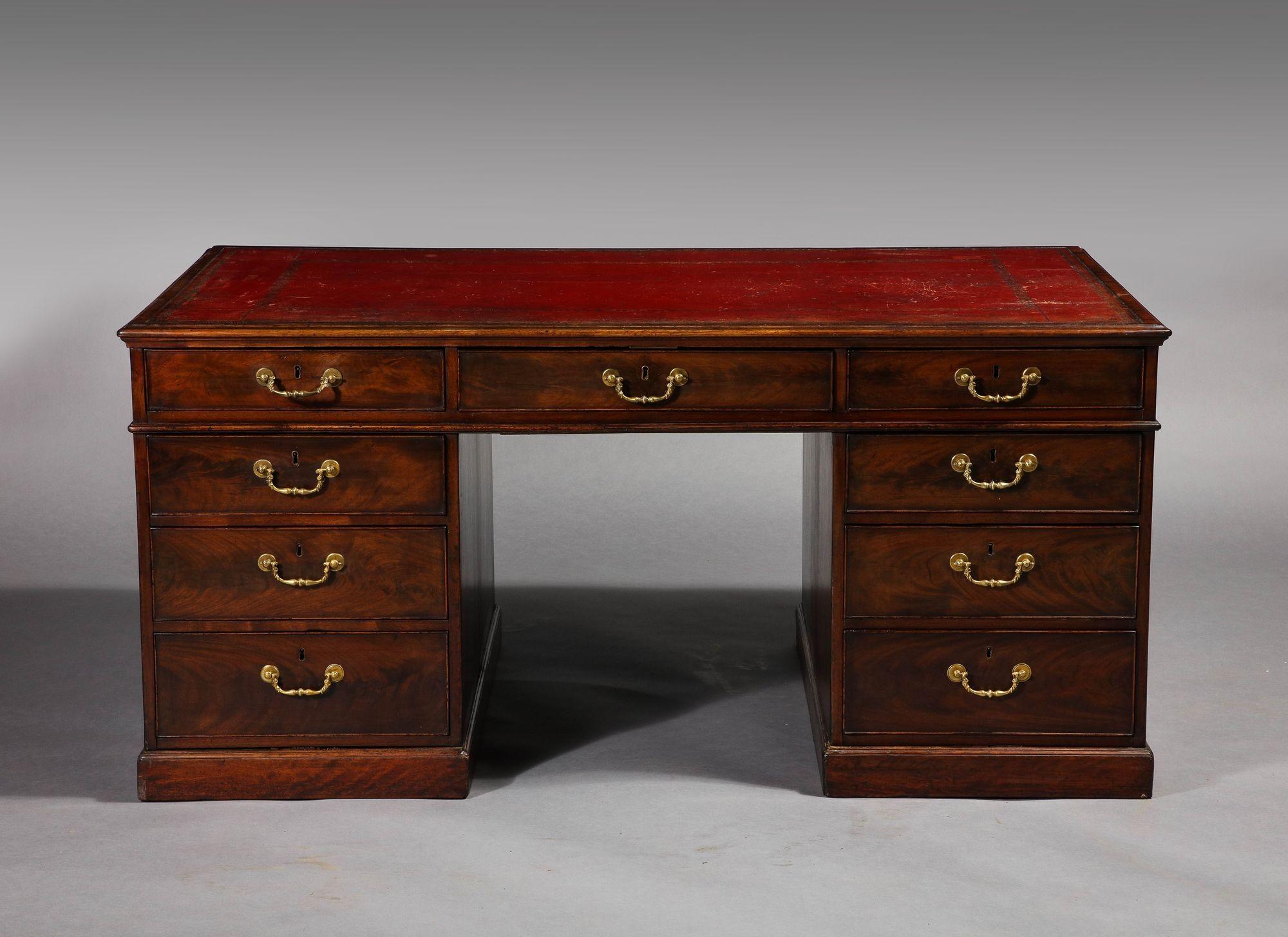 Fine and rare George III period mahogany partner's desk, the molded top with inset Morocco red leather top with gilt tooling over two sides both with two banks of working doors and retaining original gilt lacquered hardware, the whole with