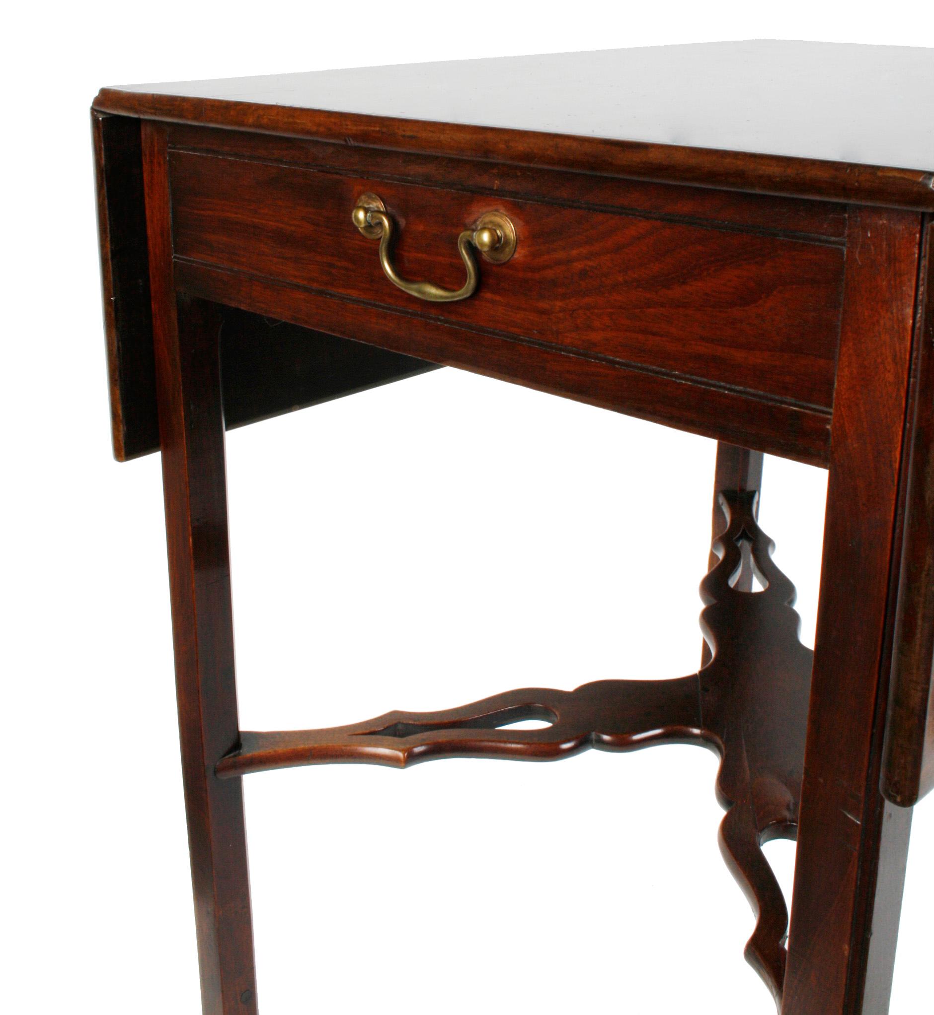 A George III mahogany Pembroke rectangular table with two drop leaves, a pierced X-stretcher and square legs. Both ends have drawers with brass pulls. When table is open it measures: 38
