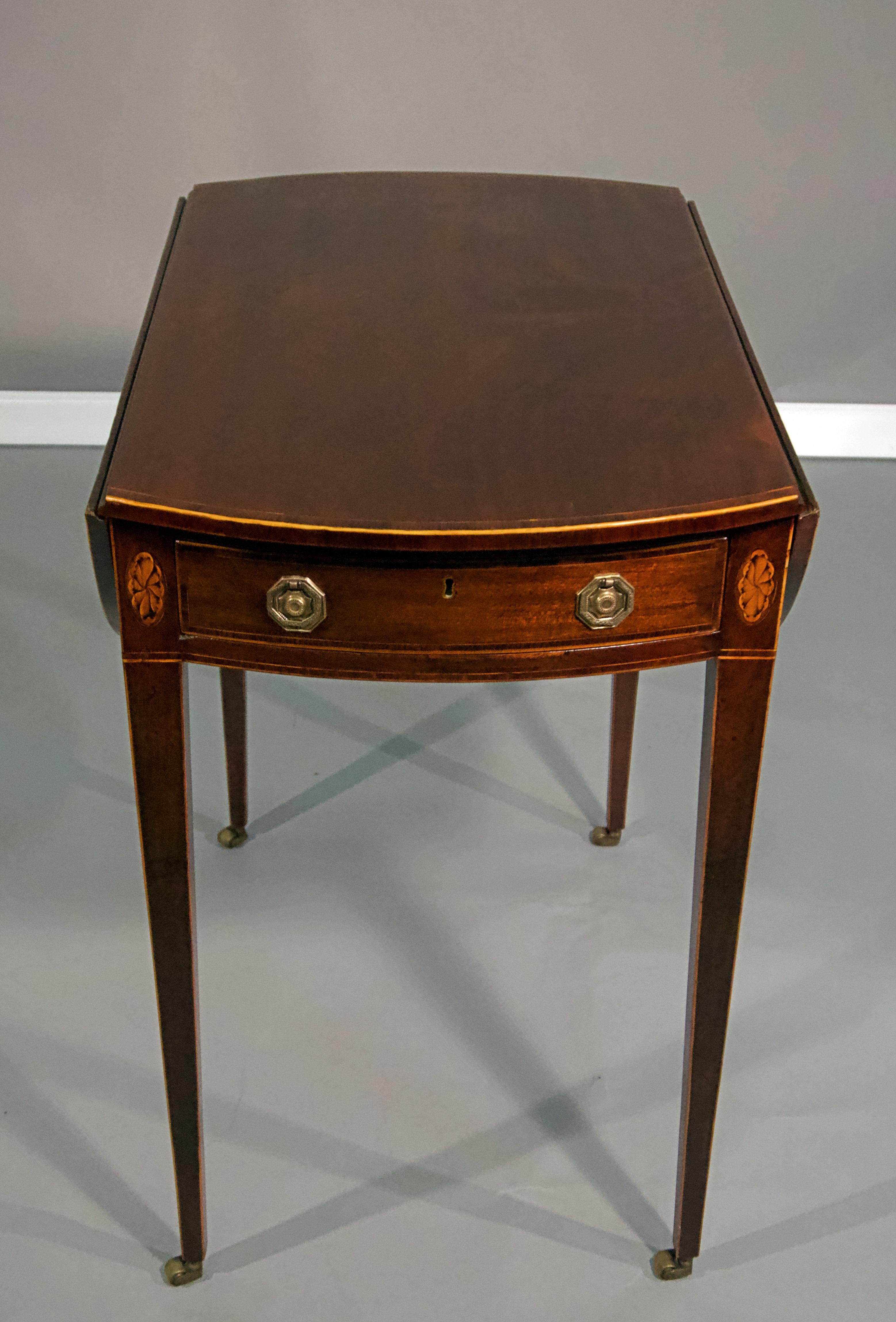 George III mahogany Pembroke table
It's crossbanded mahogany top with two drop Leaves
on a single crossbanded drawer and frieze raised on square tapering legs, topped
with shell motif panels. The legs with boxwood stringing terminating in brass