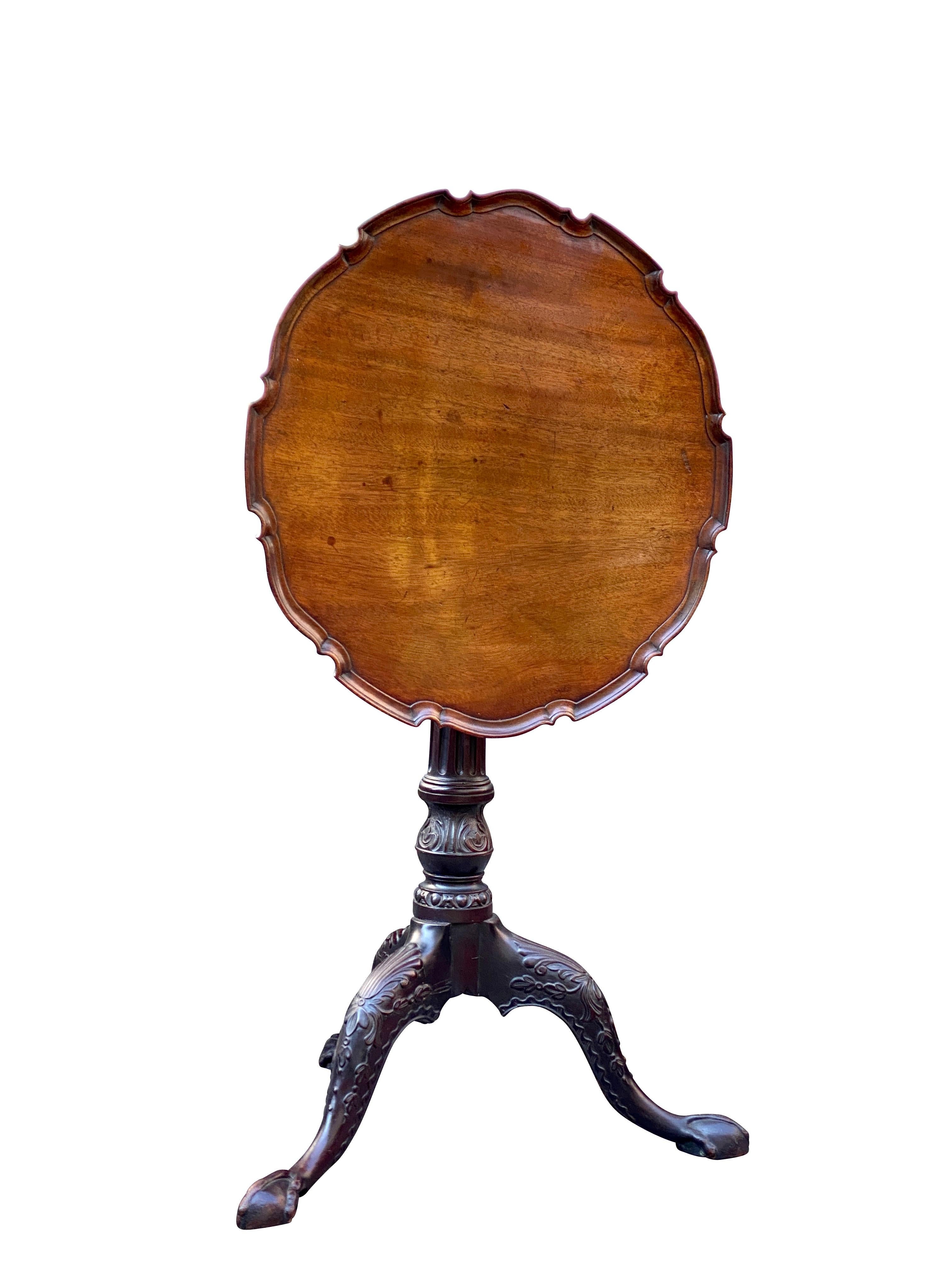 Lovely color with well carved piecrust edge to circular top, raised on a well carved fluted and carved support, ending on three carved cabriole legs with ball and claw feet.
