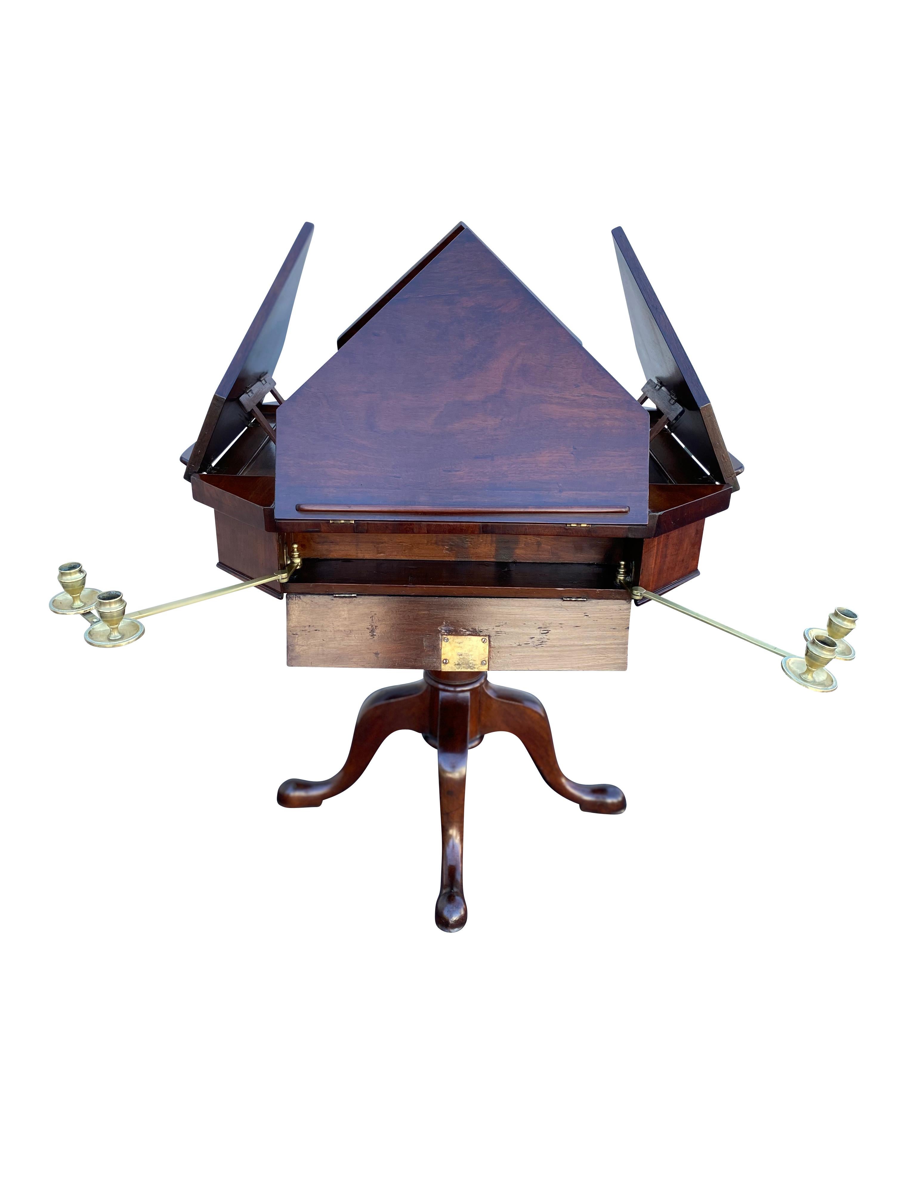 Octagonal top with four triangular ratcheted book or sheet music holders, side drawers with brass swing out candle arms, raised on a turned support ending on four cabriole legs with pad feet and casters. By repute given by Arthur Fiedler to the