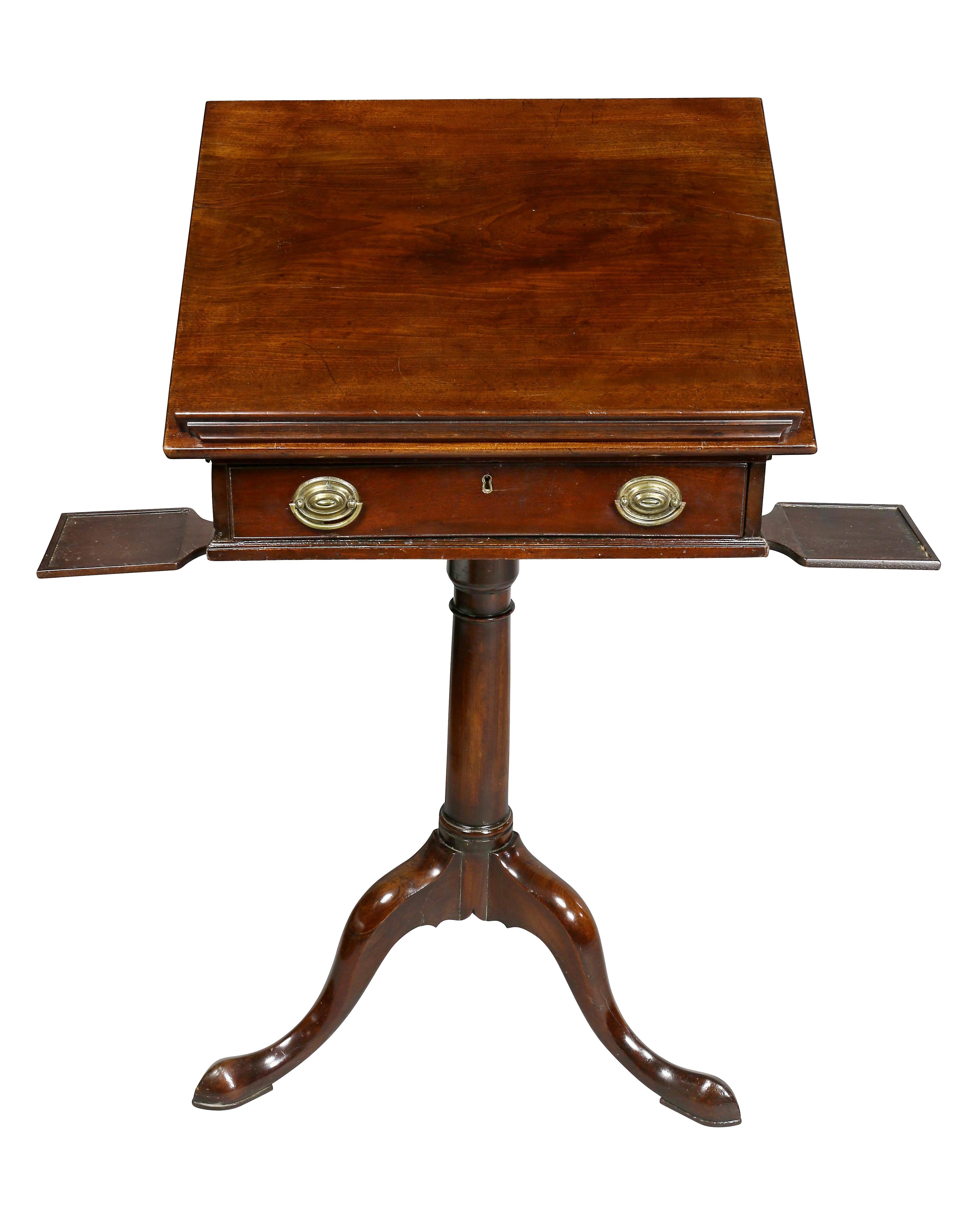 With rectangular hinged adjustable top over a drawer with oval brass handles on a turned columnar support with three curved legs and pad feet.