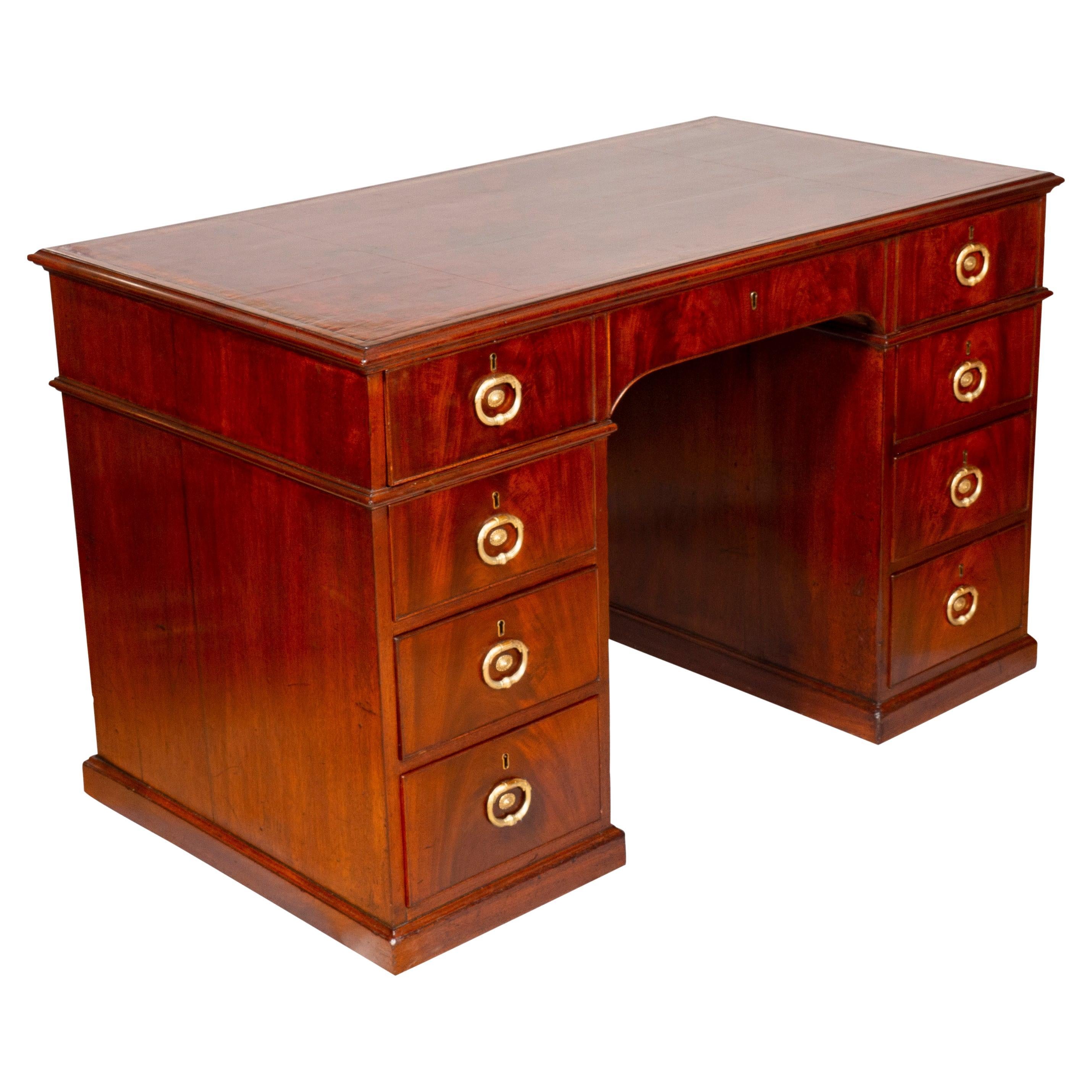 With rectangular top with inset red leather and banded edge, over a long drawer opening to A-Z lidded compartments. The pedestals below each with three drawers. All with classic Gillow handles. A similar desk illustrated in the two volume book on