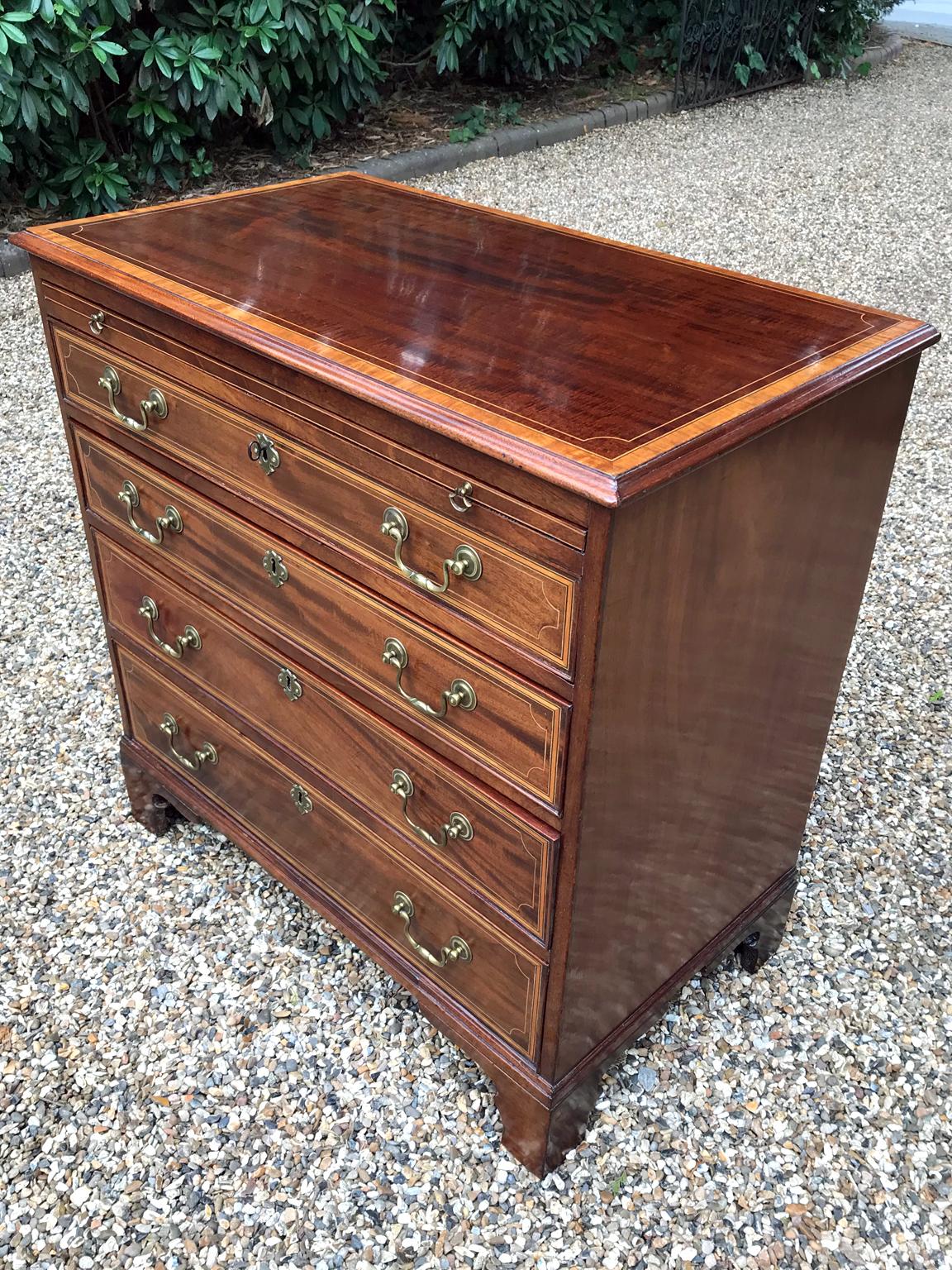 George III mahogany and satinwood crossbanded chest of drawers with brushing slide, four graduated and solid oak lined long drawers with original brass swan neck handles on bracket feet.

circa 1790-1800

Dimensions:
Width 34 inches – 86