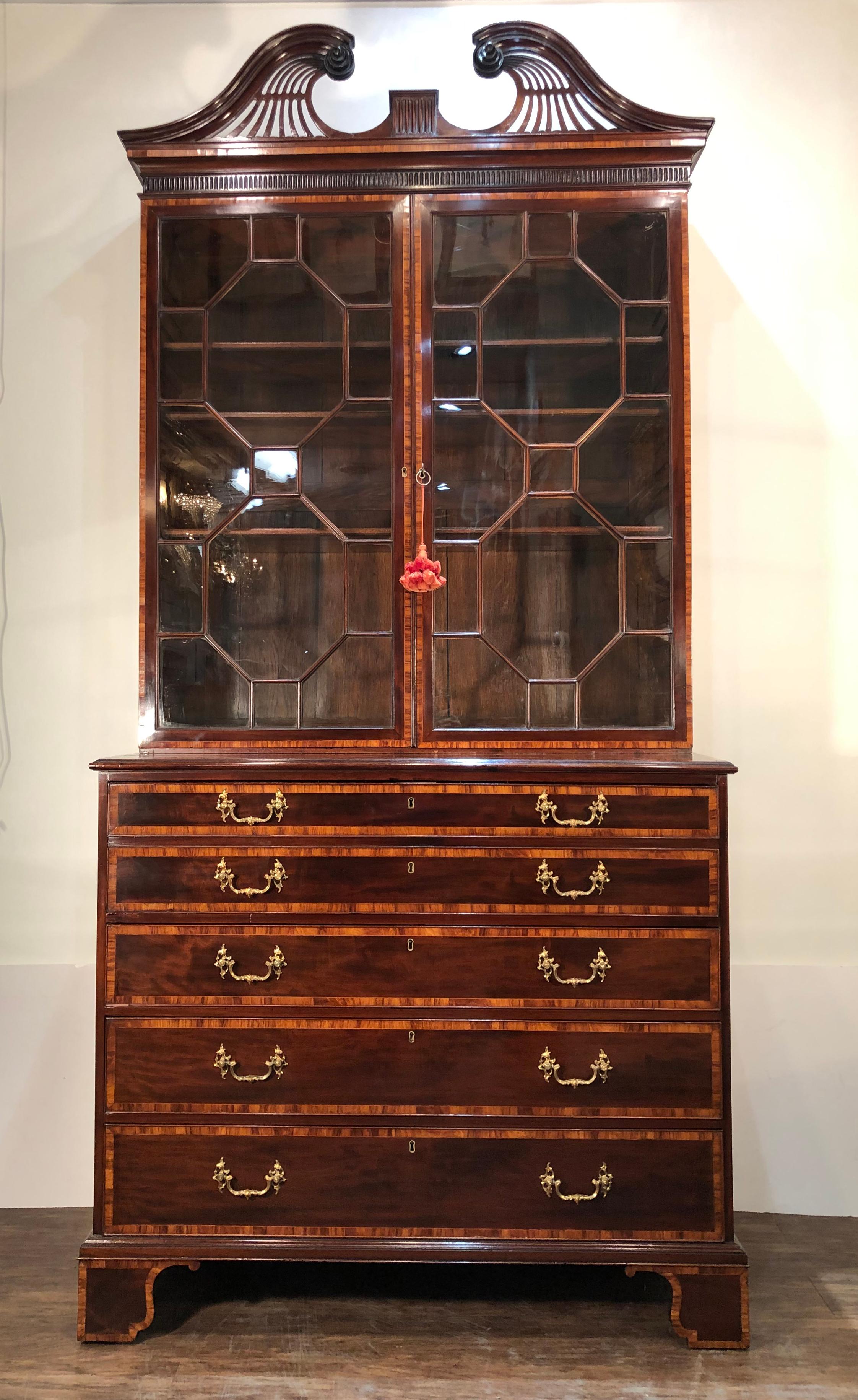 Extraordinary George III Mahogany Secretary or Bookcase, 18th century, in the manner of Henry Kettle. Pierced cornice with broken arch pediment finishing in scrolled rosettes with centralized stop fluting. The bookcase has a pair of glass doors
