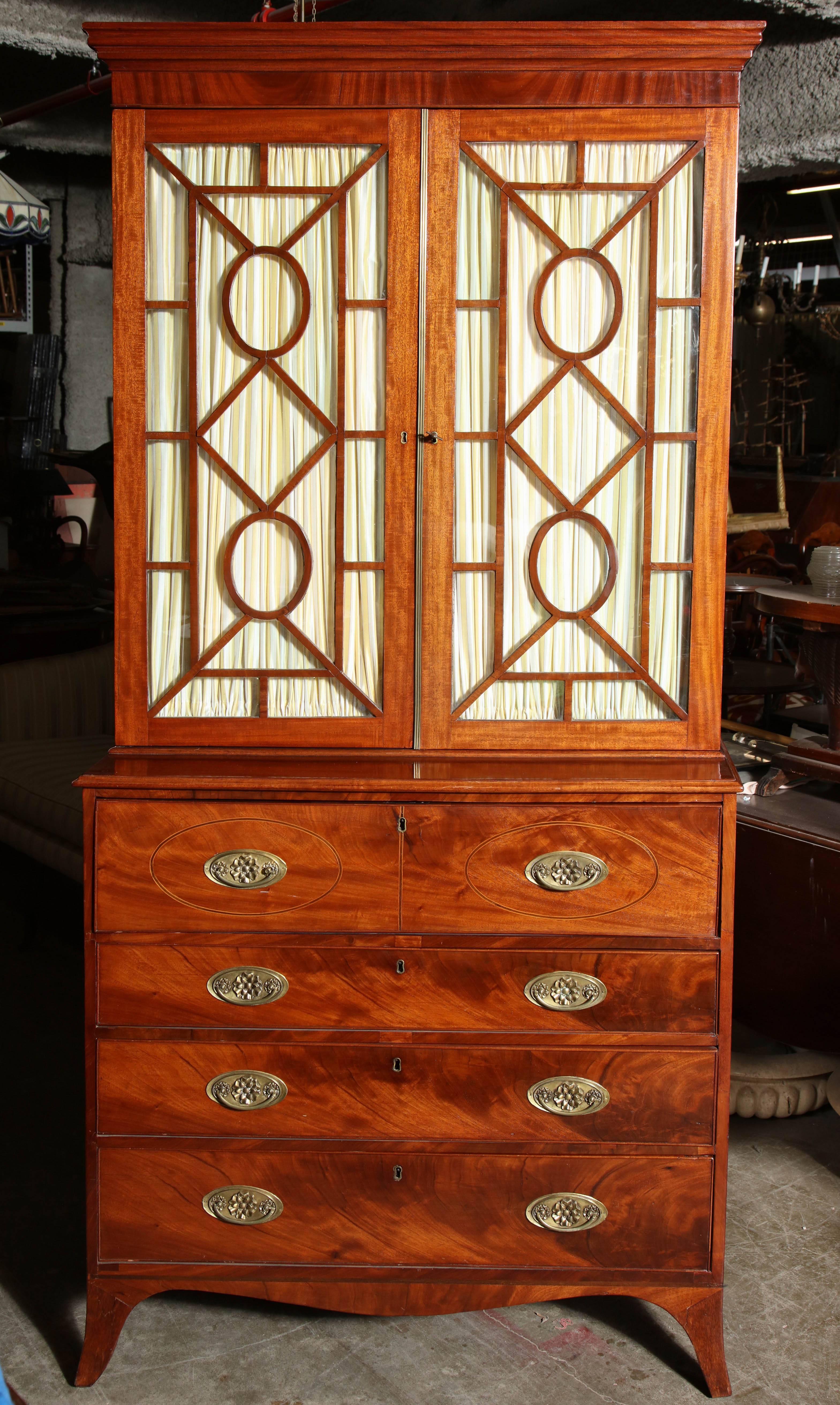 George III (Hepplewhite) mahogany and oval inlaid butler's secretary desk in two parts on French feet with shaped apron, glass mullion doors, fitted interior with pigeon holes and satinwood drawers.