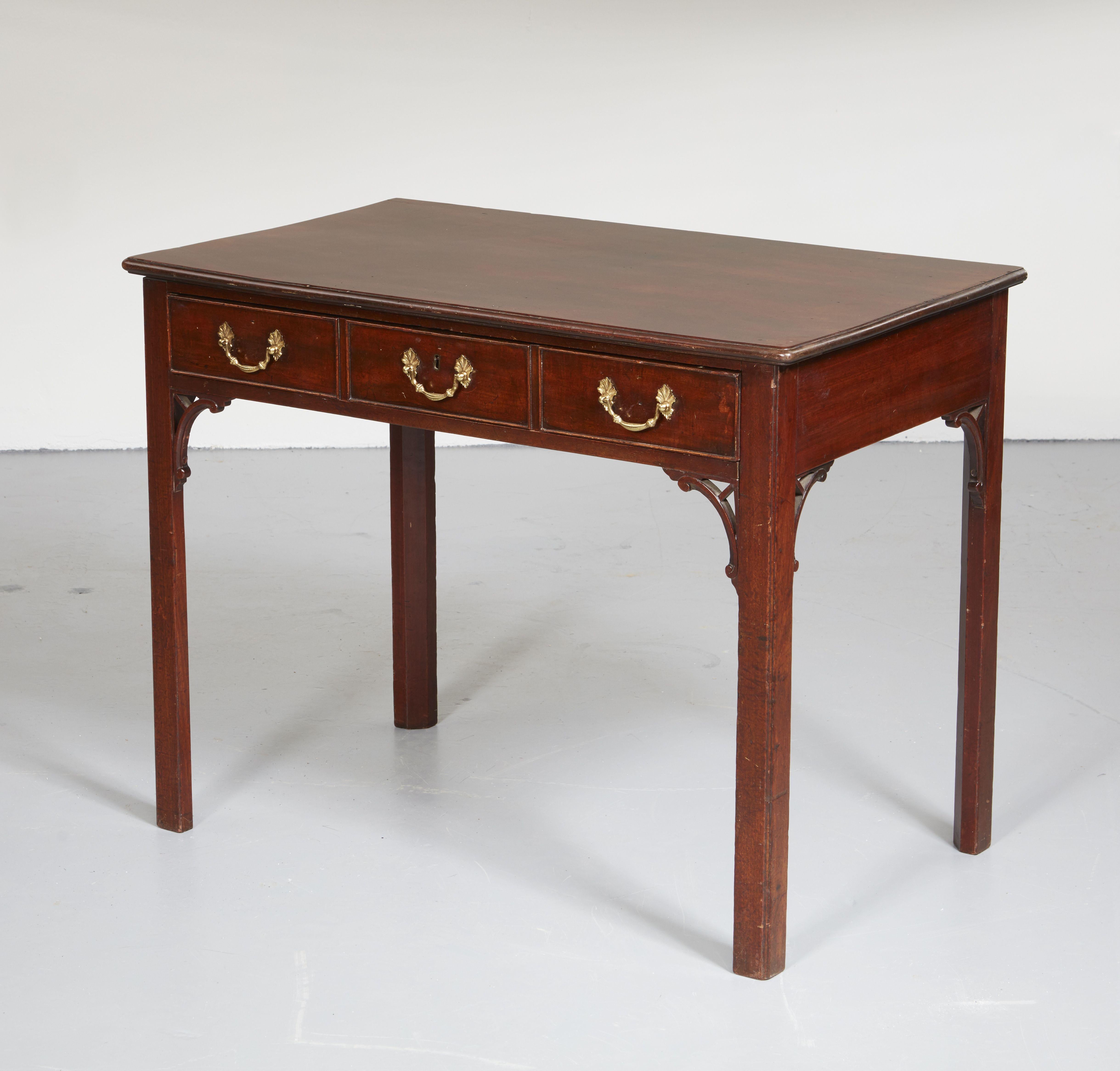 Very fine Chippendale period mahogany side table in the manner of Thomas Chippendale, with richly grained top over single drawer (fashioned to appear as three) retaining original fire gilt handles and having carved spandrels, standing on square legs