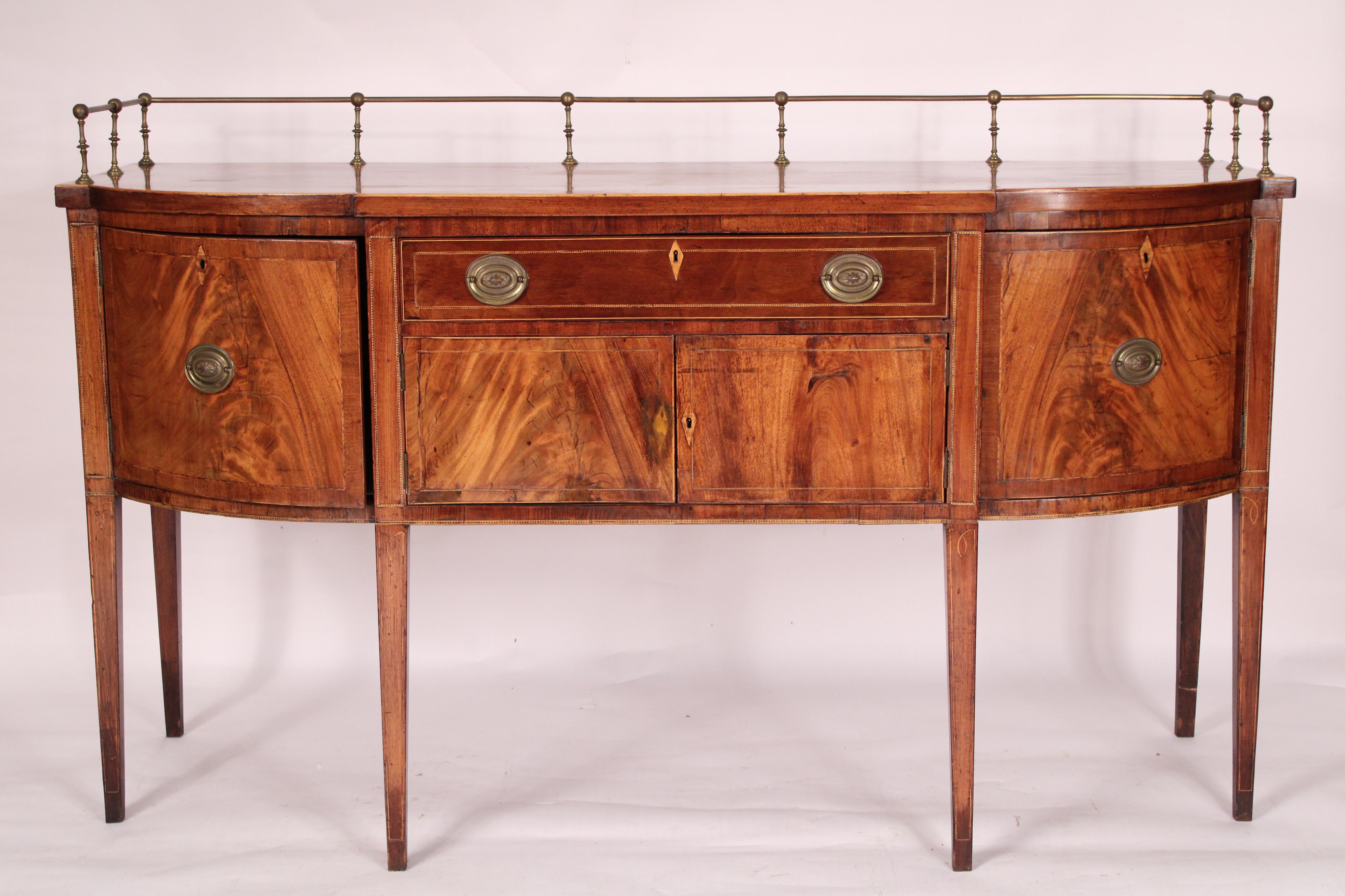 George III Mahogany Sideboard, circa 1800. With original brass curtain rails, a mahogany top with box wood stringing on the front and side edges, a mahogany drawer below and two flame mahogany doors with inlay, flanked by two convex flame mahogany