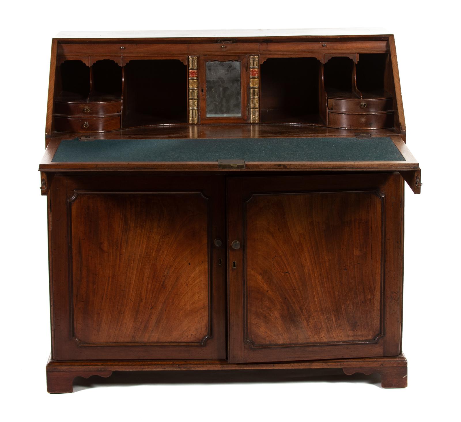 A George III mahogany slant-front desk
Third quarter of the 18th century
the rectangular top above a slant front enclosing drawers and fitted compartments, over a long drawer above a pair of cupboard doors enclosing two later sliding shelves,