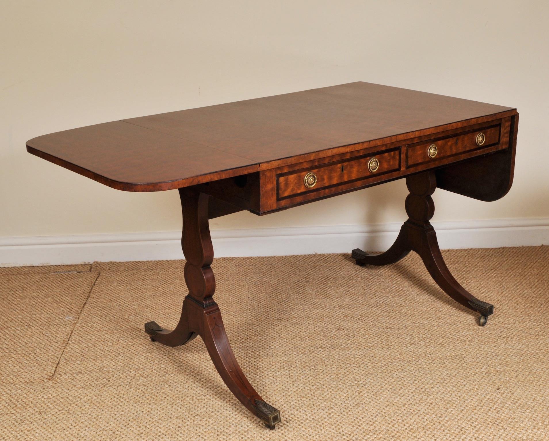 George III mahogany sofa table, circa 1785

A fine George III figured mahogany sofa table. The rectangular top has black ebony stringing. It has two drawers to the front and two dummy drawers to the rear with original brass handles. This table is