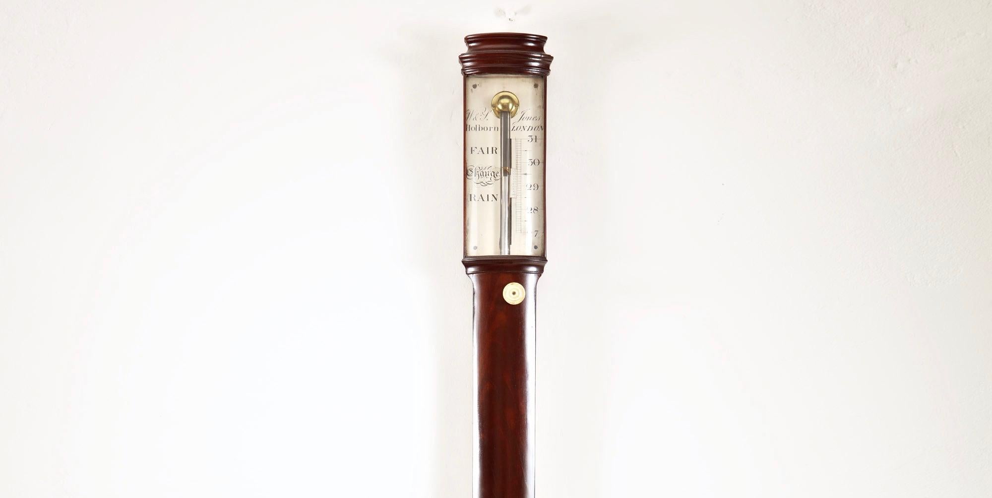 A fine George III mahogany stick barometer by noted London makers William & Samuel Jones. 

The mahogany-veneered case has an austere form with only the moulded caddy top and the urn-shaped cistern cover to break its soberness. The silvered