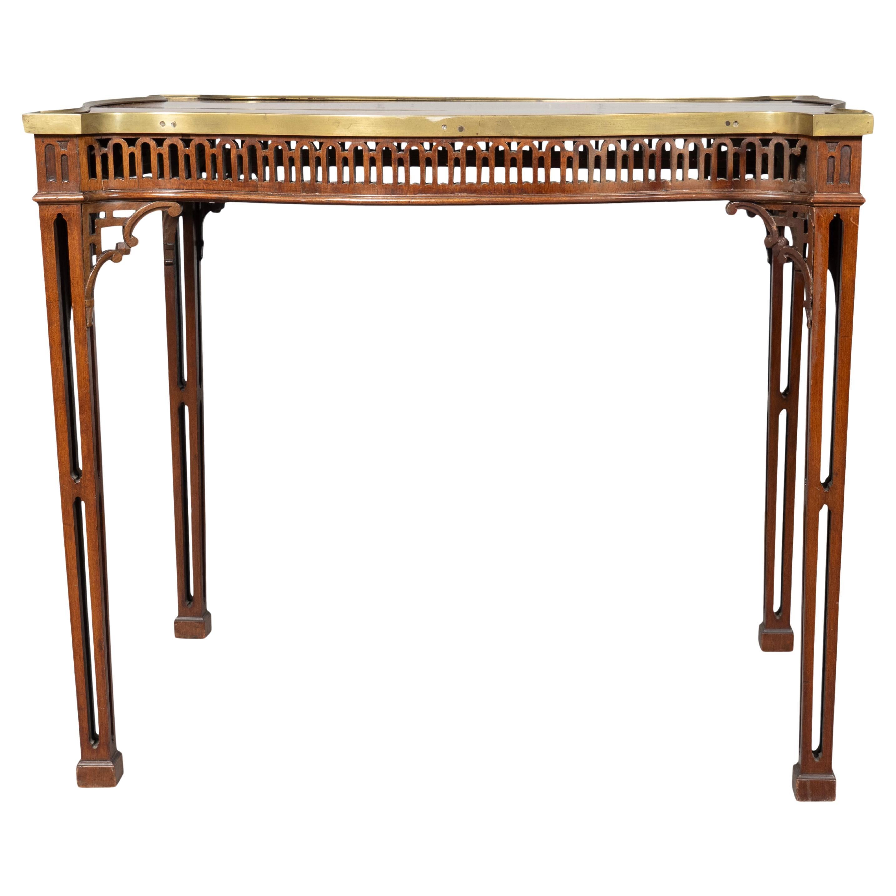 Shaped rectangular top with brass bound edge with conforming fret carved frieze. Tapered square fret carved legs.