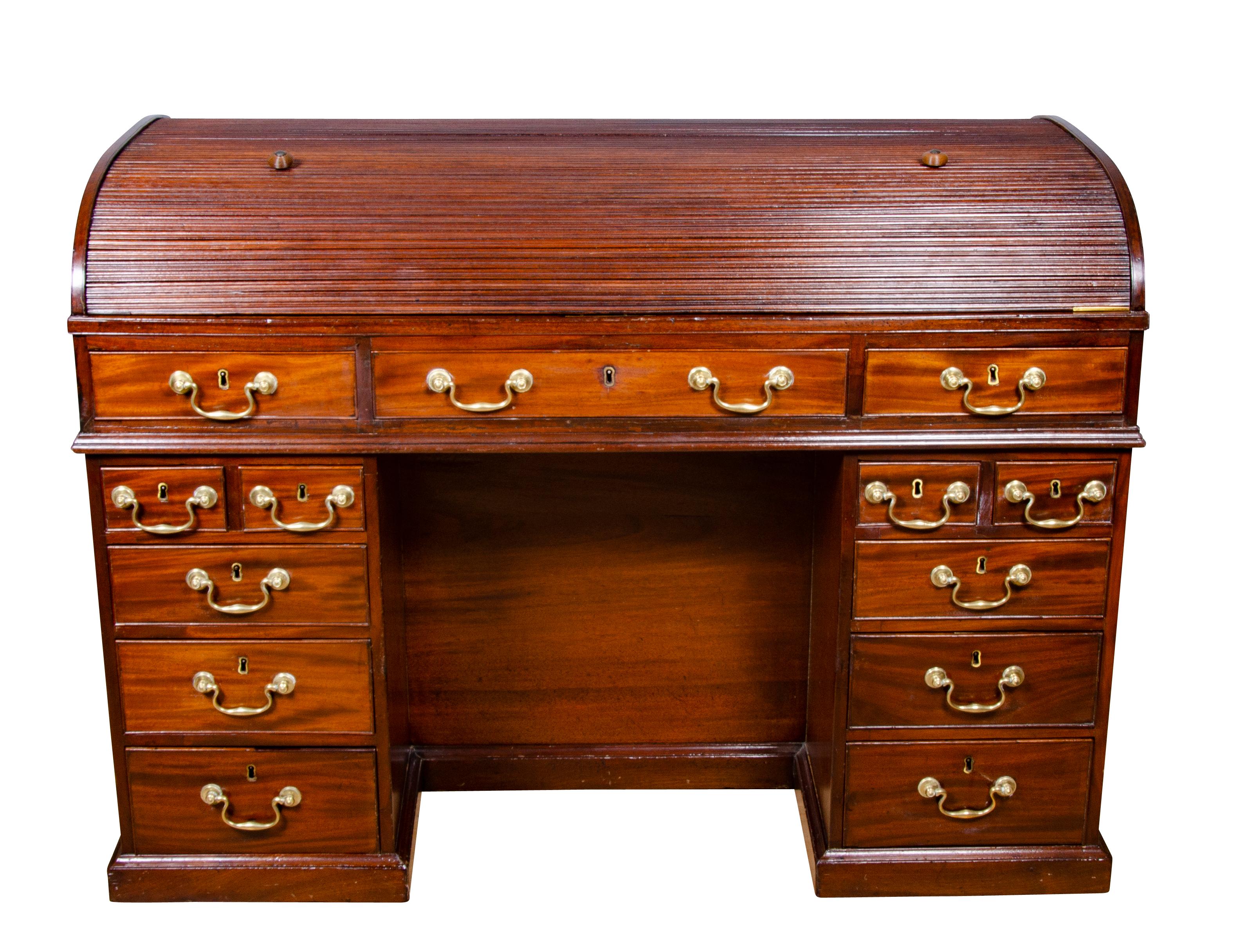 Beautiful quality with tambour roll top opening to expose a fitted desk with drawers, cubby holes and leather writing surface, over a long drawer flanked by a small drawer over pedestals with drawers surrounding a kneehole , the back with three