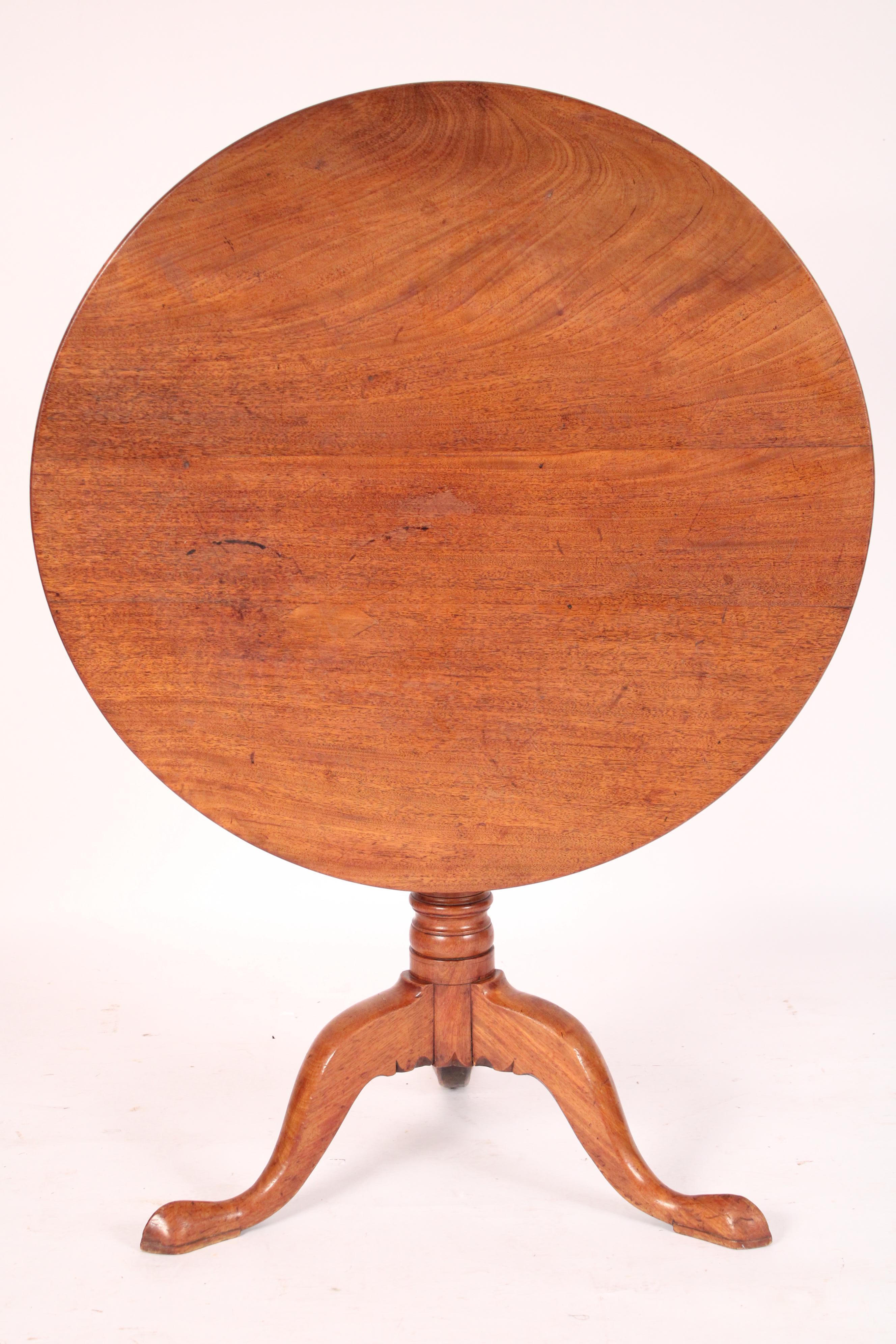 Table à plateau basculant en acajou de George III, XVIIIe siècle. Avec un plateau rond à 3 planches aux bords arrondis, un piédestal tourné en balustre et anneau et 3 pieds balancés vers le bas. Belle couleur acajou clair. 