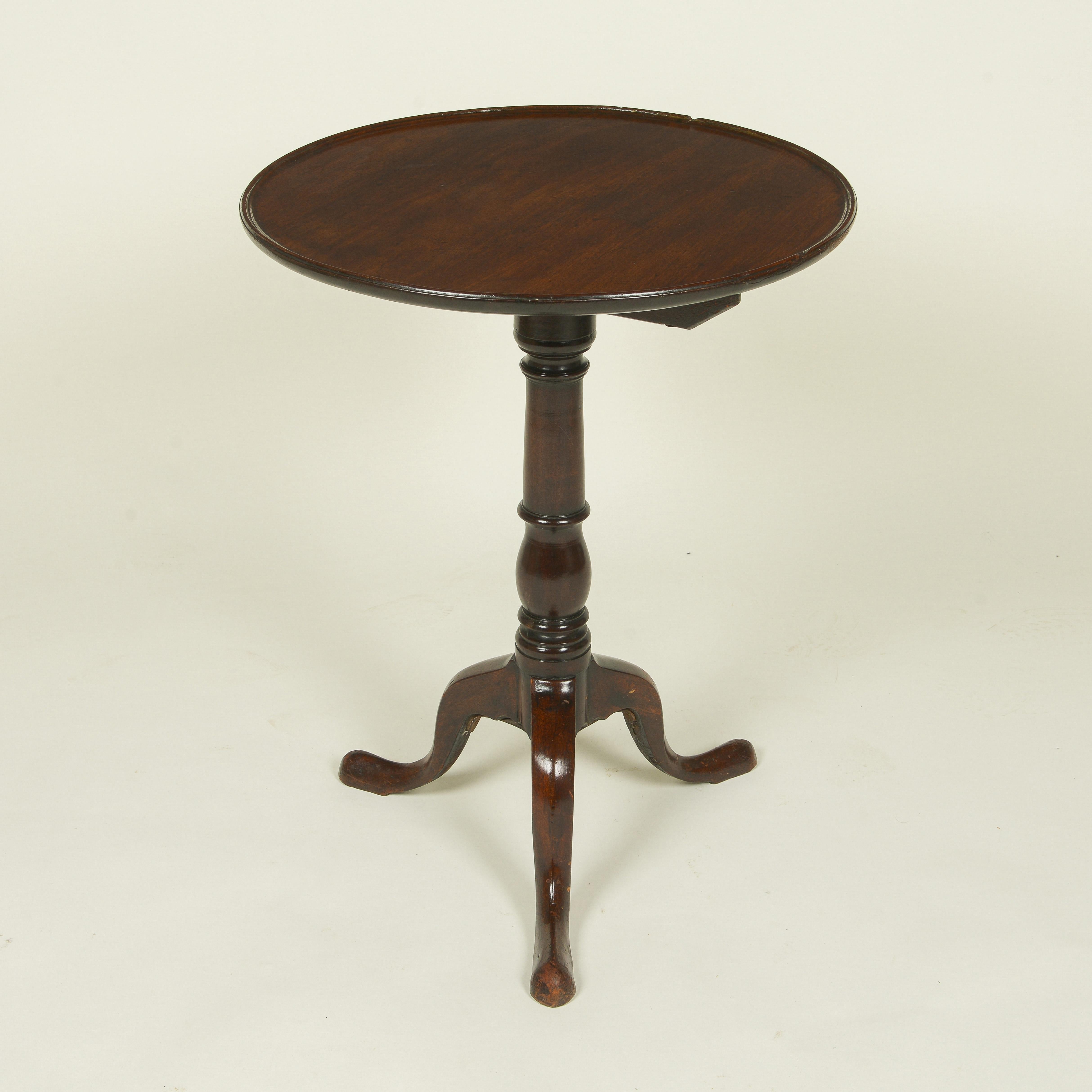 The round top with dished top; raised on a turned columnar support on three downswept legs terminating in pad feet.