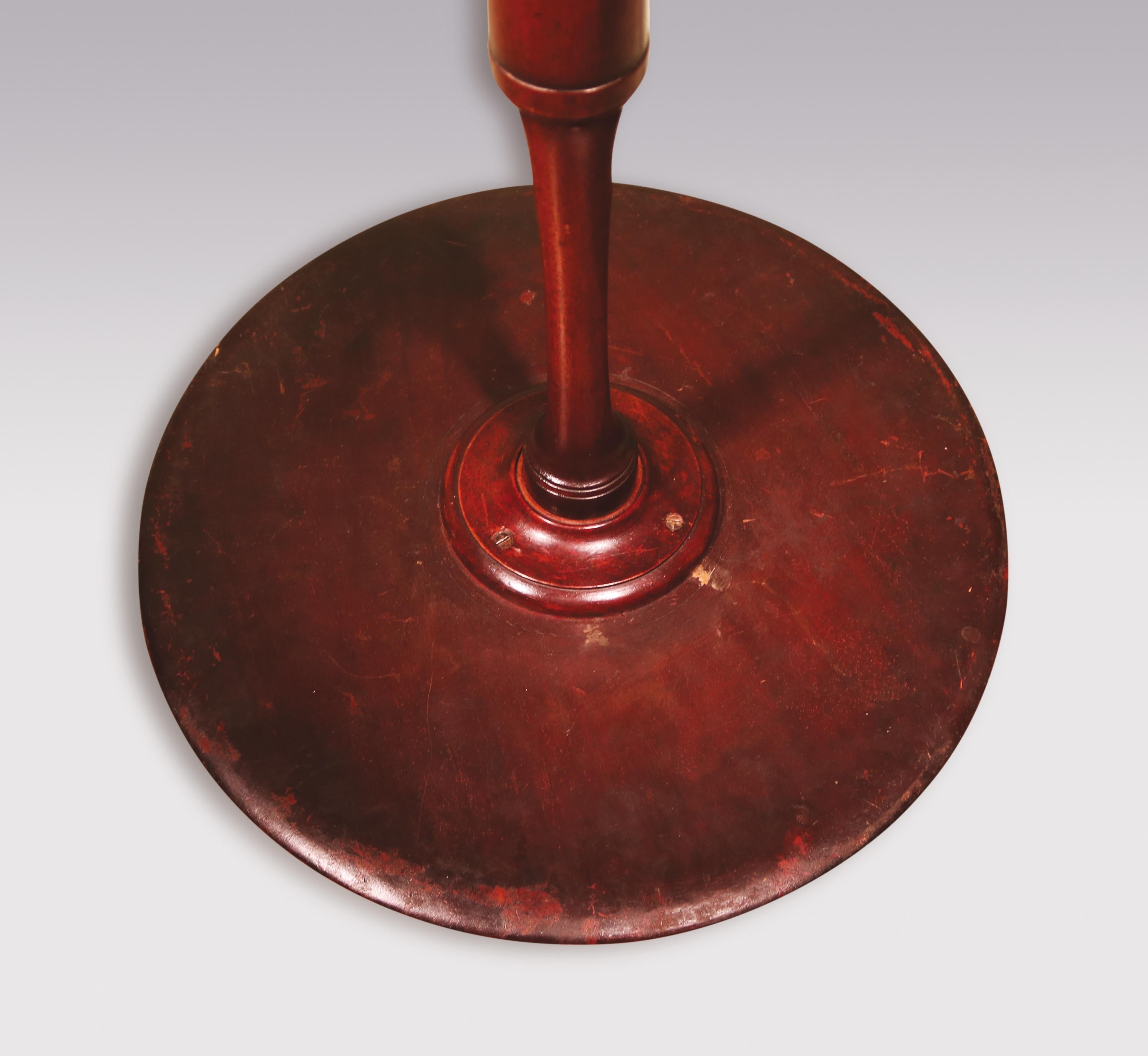 A George III period figured mahogany tripod table having circular 'dish' top, raised on vase-turned stem, supported on triple sided umbrella shaped legs, ending on spade toes.
