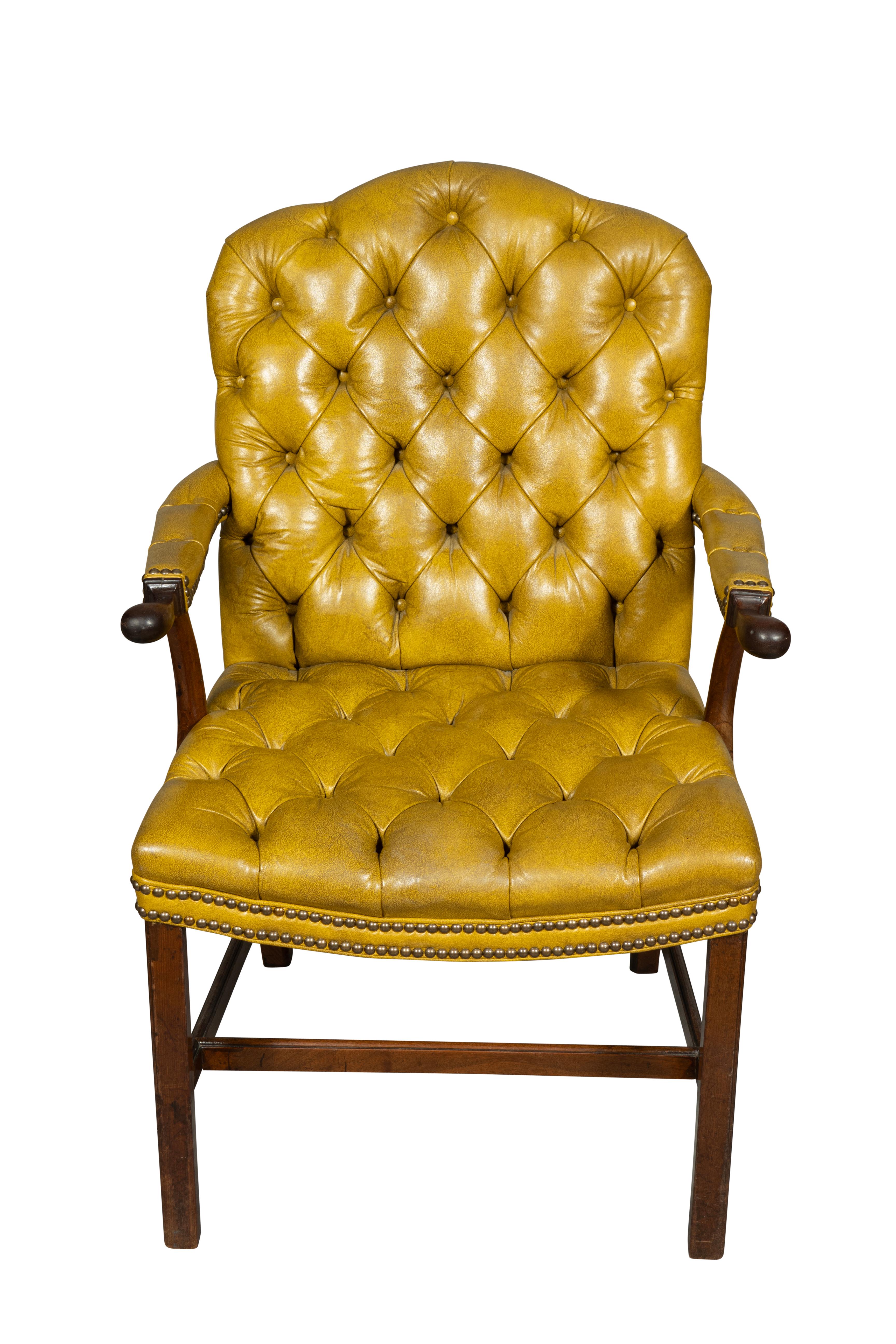 Con respaldo y asiento empenachados de color amarillo mostaza. Brazos perfilados con cuero empenachado y patas de sección cuadrada con camillas en forma de H.
