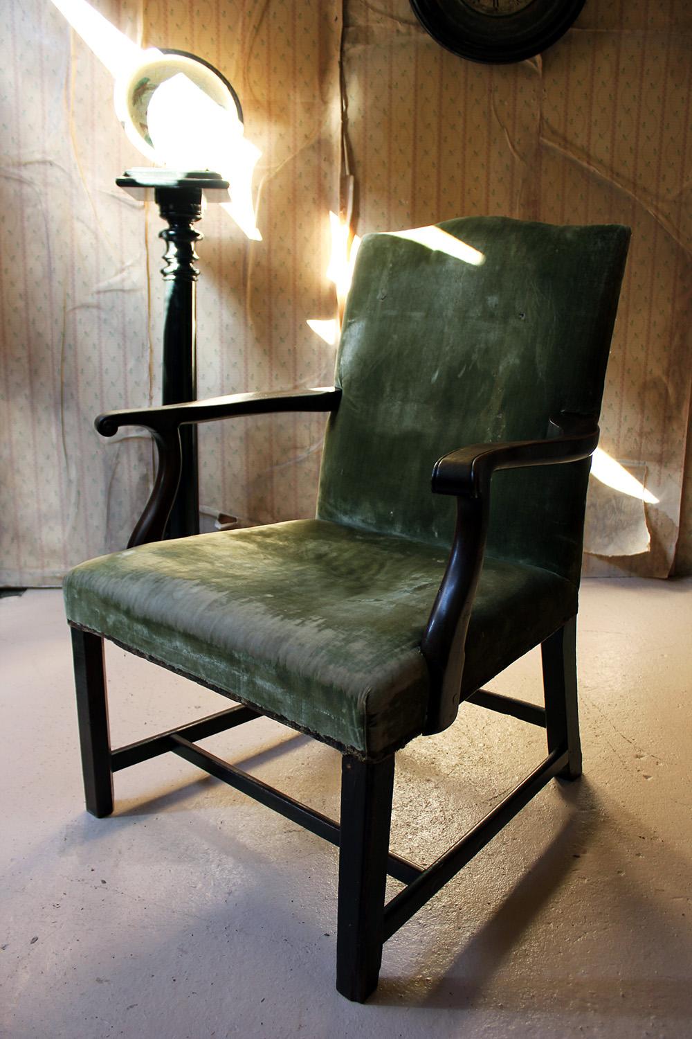 The good quality country house open armchair with a mahogany carcass, the serpentine shaped back with scroll arms above a padded seat, on square chamfered legs united by an h-stretcher, the whole retaining its nineteenth century bottle green velvet