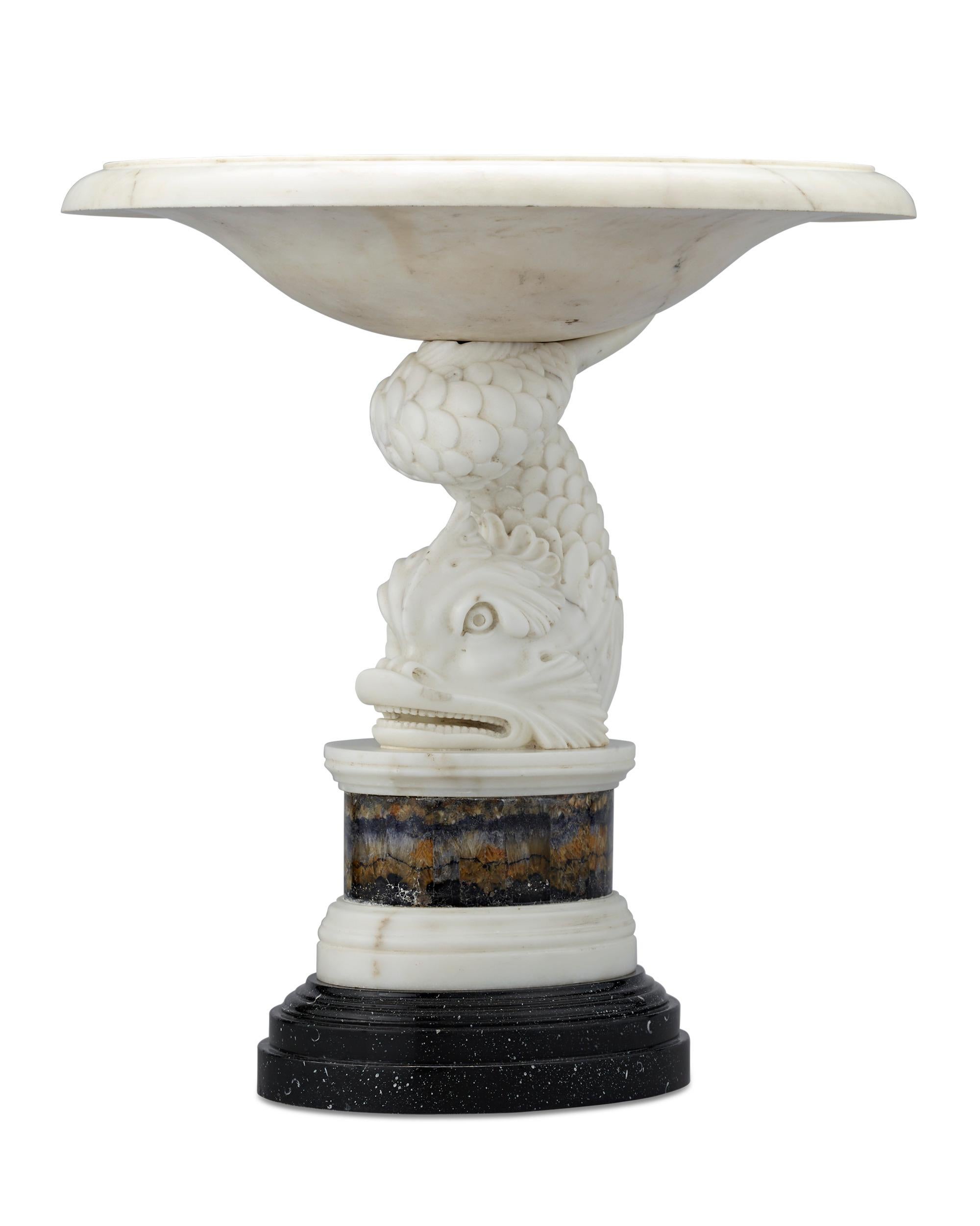 This important George III tazza is attributed to famed Scottish-Swedish architect Sir William Chambers. The magnificent piece features a base carved from statuary marble in the shape of a stylized dolphin, which relates to Chambers' extraordinary
