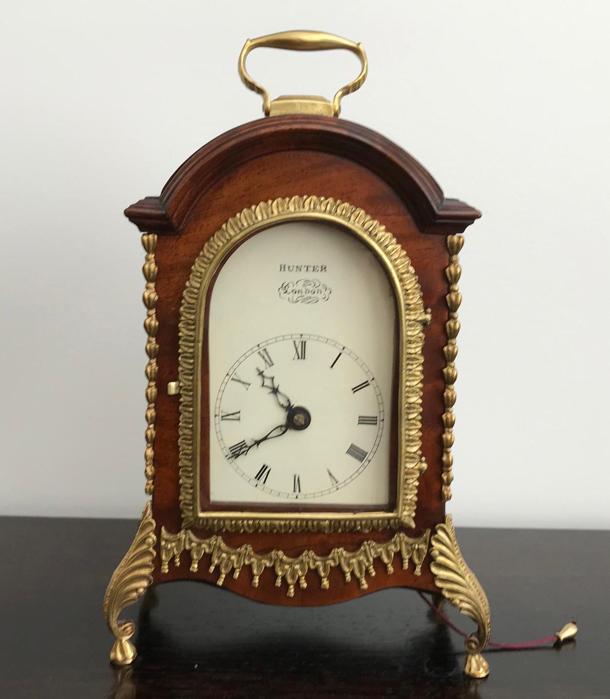 Exceptionnellement rare horloge de cheminée miniature à double fusée de George III, vers 1790. Le coffret en acajou est doté de frettes sonores en laiton sur les côtés et d'une décoration détaillée sur le devant du coffret, de pieds décoratifs en