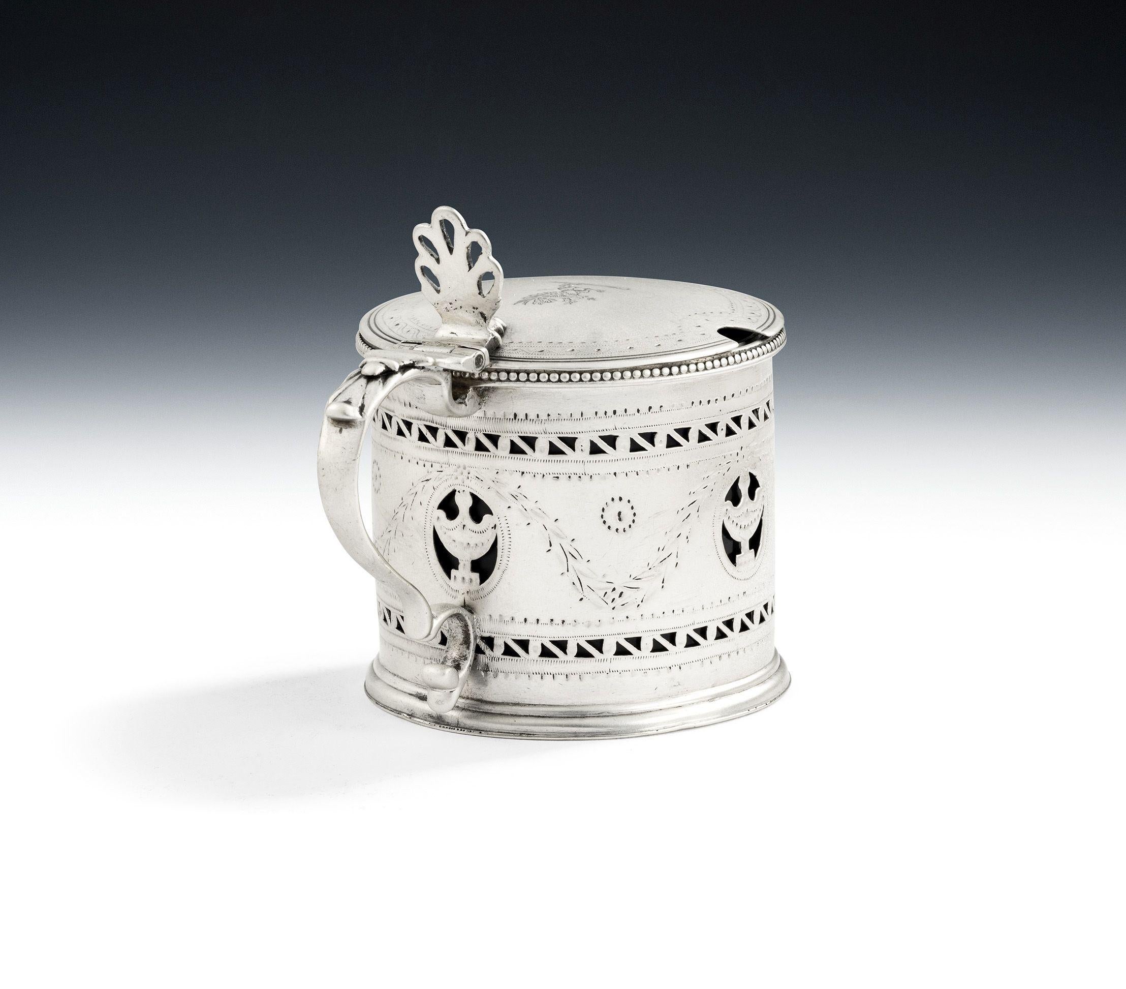 Fino tarro de mostaza de Jorge III fabricado en Londres en 1781 por Robert Hennell.

El pote de mostaza está modelado en forma de tambor, con una base extendida y un borde rebordeado.  Los laterales están perforados con bandas horizontales de