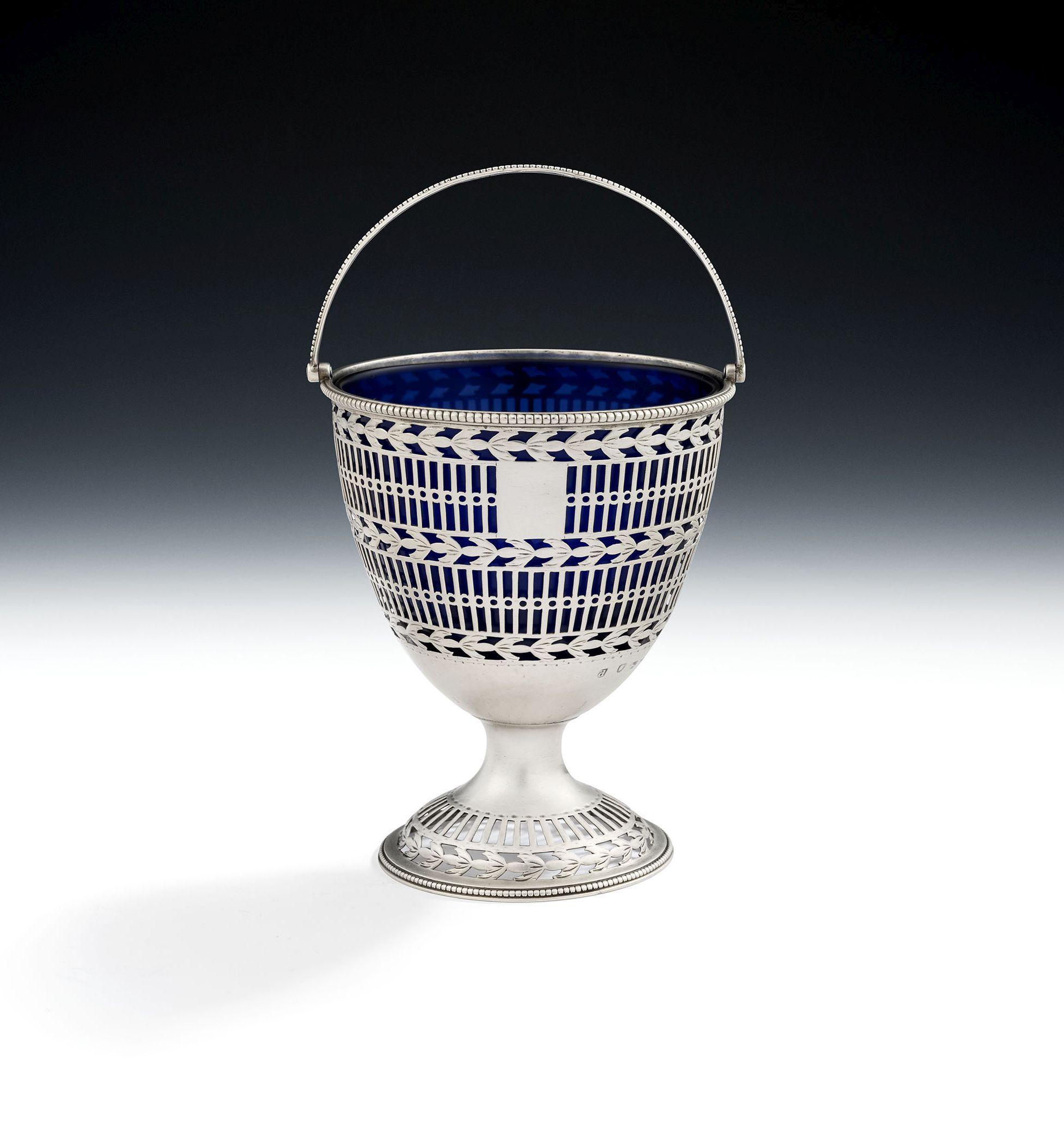 A very fine George III Neo Classical Sugar Basket made in London in 1779 by Hester Bateman.

The Sugar Basket stands on a circular domed foot, with beaded edge, which is pierced with vertical pails and blue bell drops.  The main body is modelled in