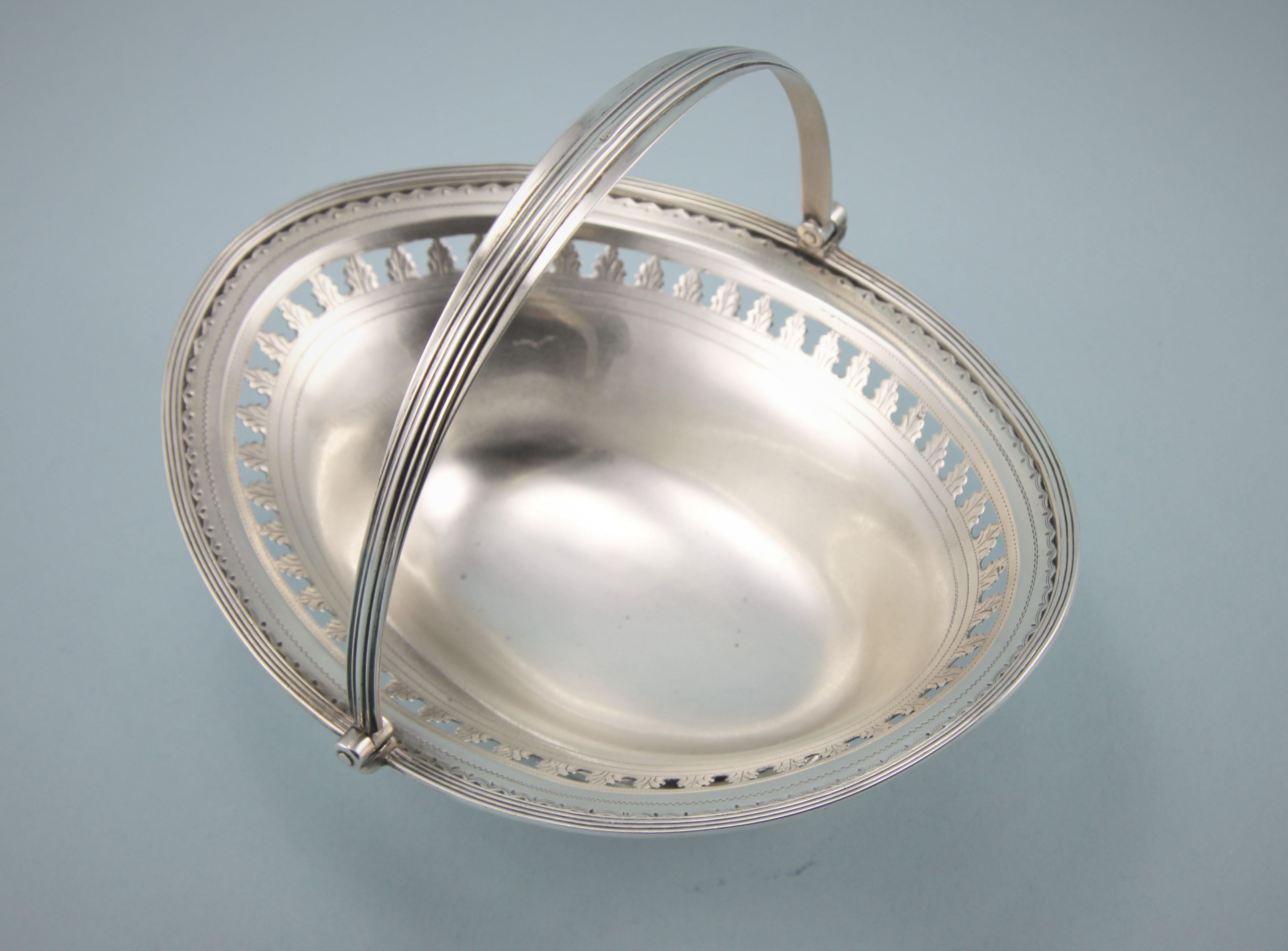 Elegant and rare George III Newcastle sterling silver swing-handled sweetmeat basket of good weight. 
Maker: John Robertson. Newcastle circa 1797. 

This basket stands on a collet foot with a band of reeding on the base. The rim of the basket is