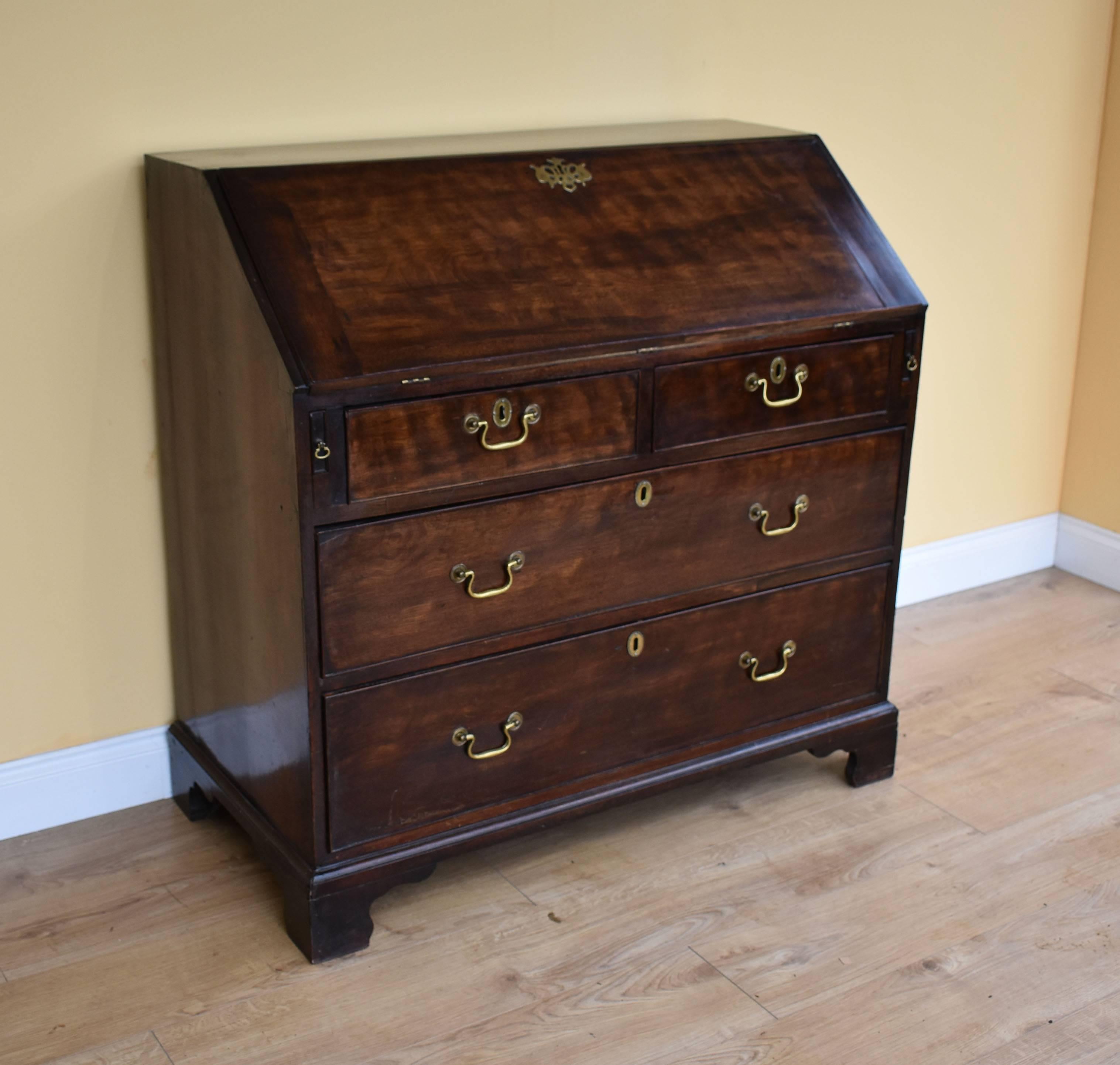 For sale is a good quality, George III oak and elm bureau. The fall front opens to reveal a fitted interior with a green leather writing surface, with decorative gold tooling. This is above two short drawers, with a further two long drawers below,