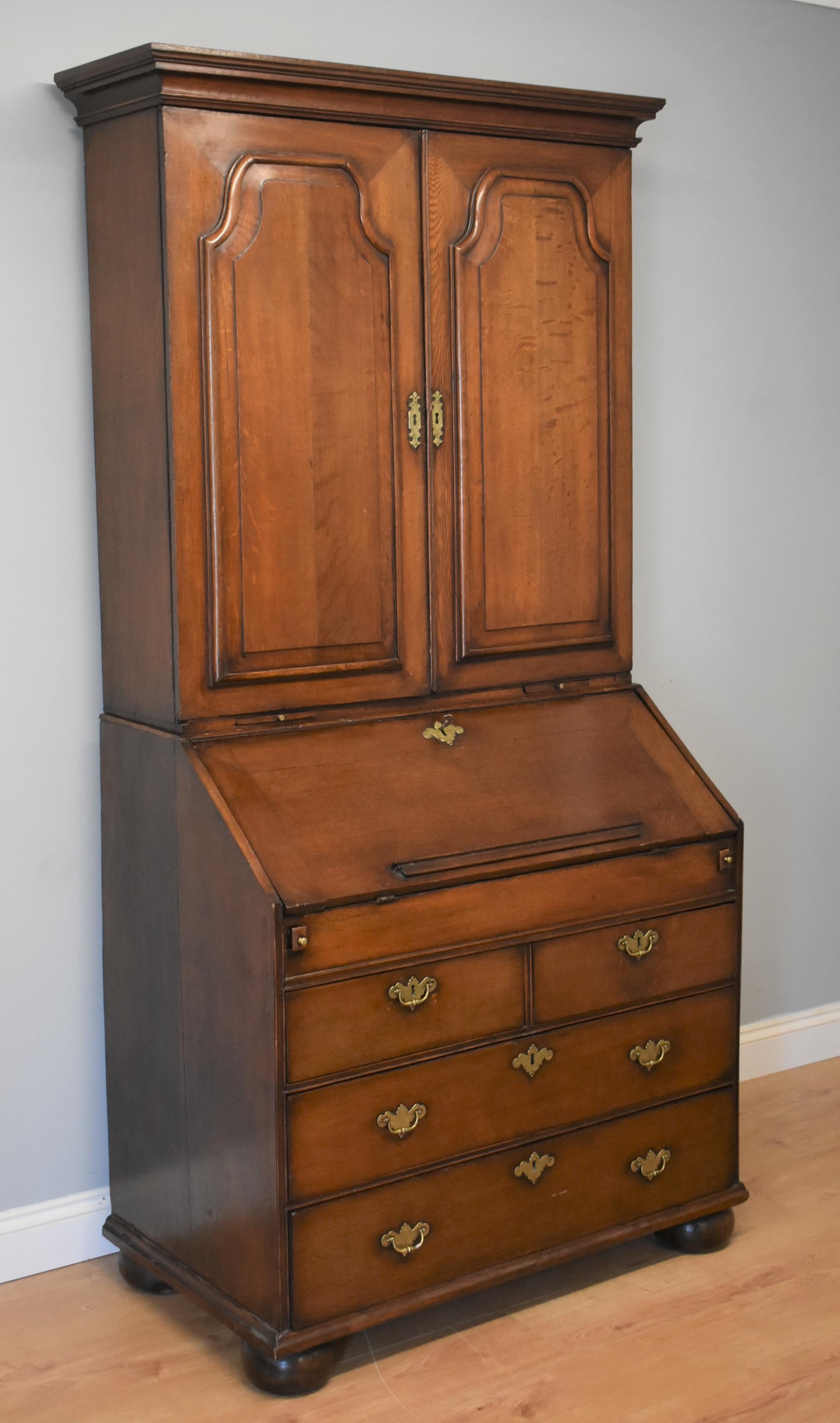 George III antique oak bureau bookcase in good condition with arched panelled doors to the top, when opened reveals a fitted interior with pigeon holes small drawers and central cupboard with a adjustable shelf above. The Bureau bookcase has candle