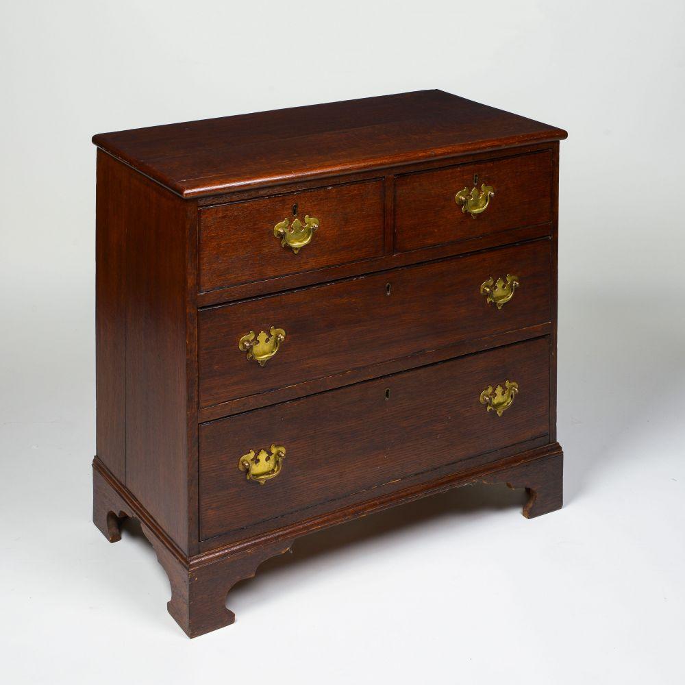 The rectangular top with molded edge, over two short and two long drawers lined with 18th century blue tissue paper, and mounted with brass pulls; raised on bracket form feet.