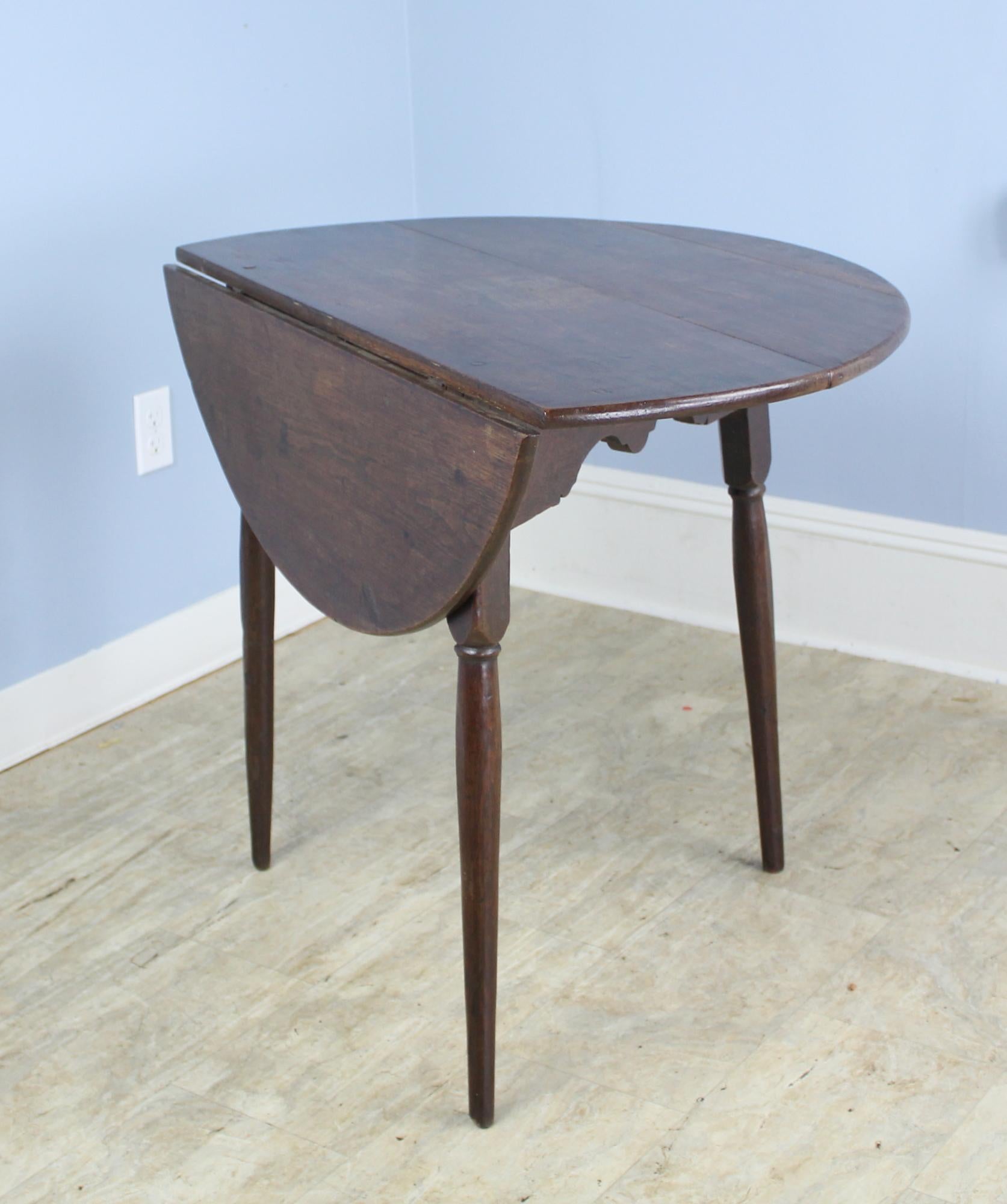 An early Scottish oak cricket table with a drop down top and finely articulated legs. The tripod base is supported on a whimsically carved apron. The top is in good antique condition with interesting distress and Fine patina. Would add a rare and