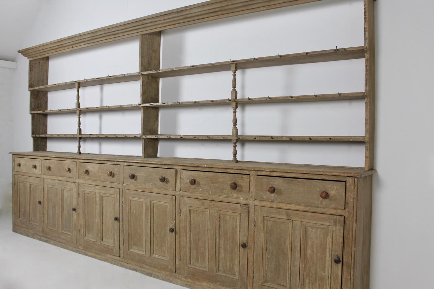 A truly wonderful and rare, George III period, Welsh country house pine kitchen dresser and rack of huge proportions. Standing at just over fourteen foot long, dry scraped back to its original paint, retaining most of its original cup hooks and