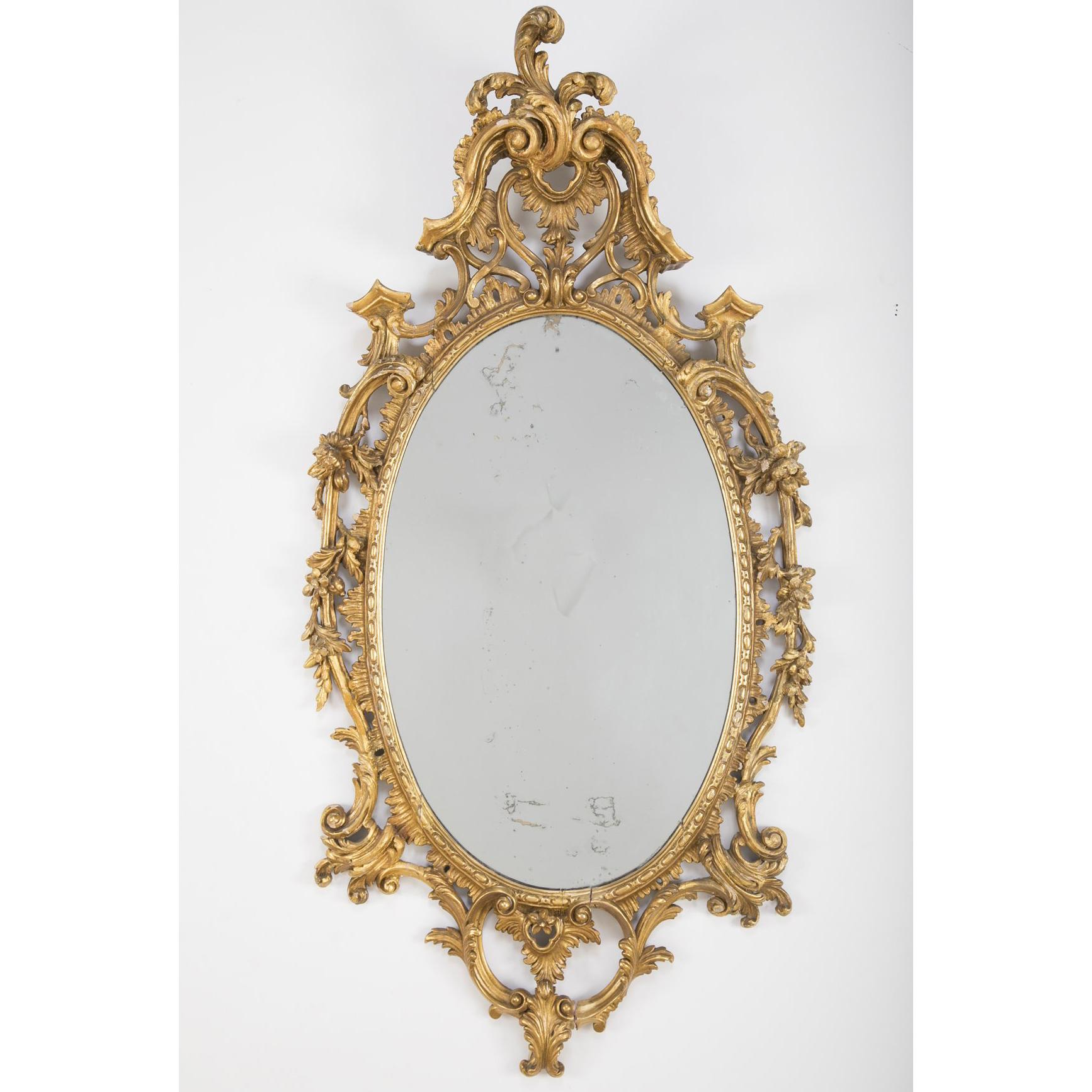 George II carved giltwood oval mirror in the Rococo style of Thomas Chippendale. With elaborately carved molding, leaves and vines.
 