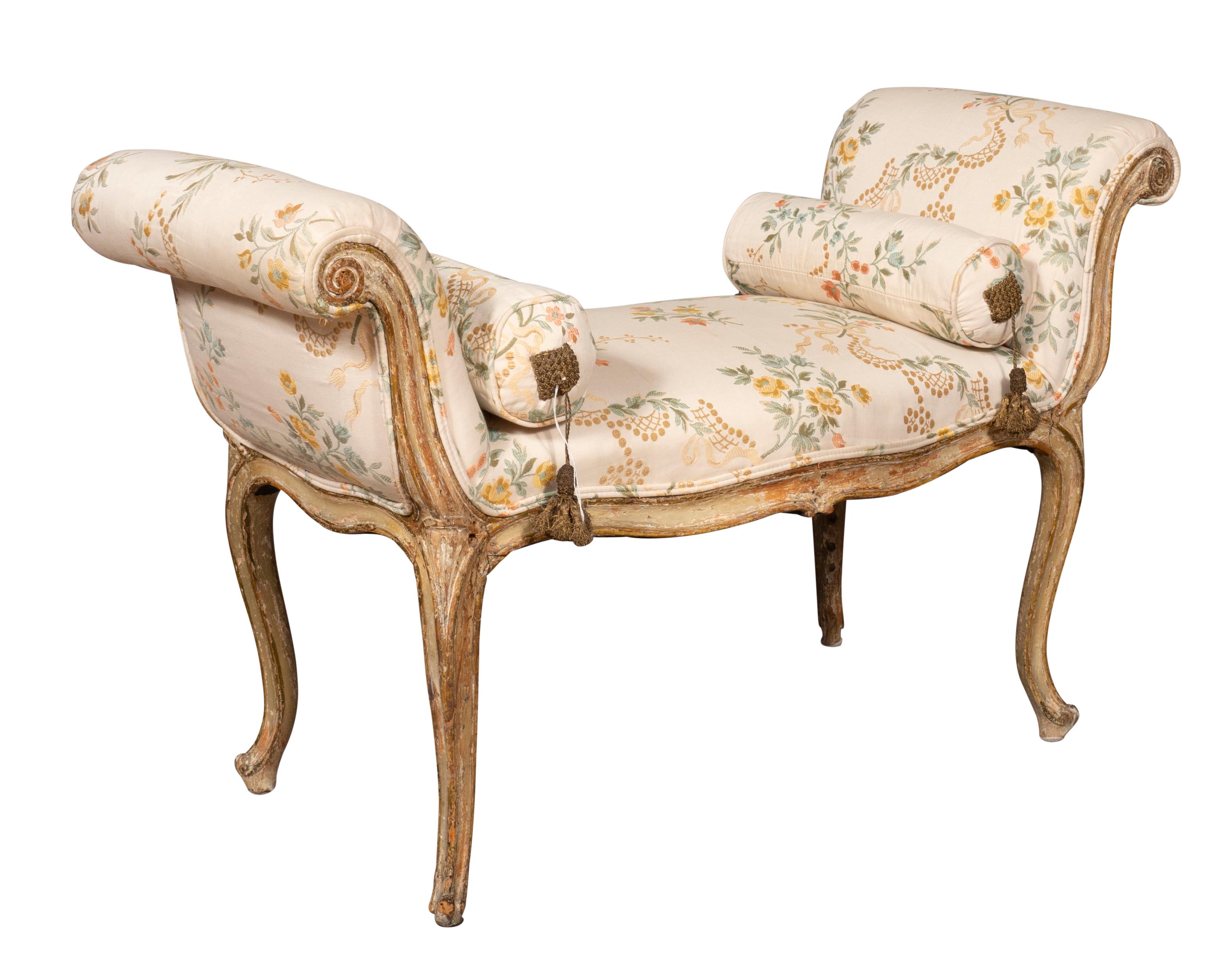 With wonderful old painted surface with good lines. With scrolled arms and cabriole legs in the French taste. Upholstered in a silk fabric with bolster pillows. From a Florida estate.