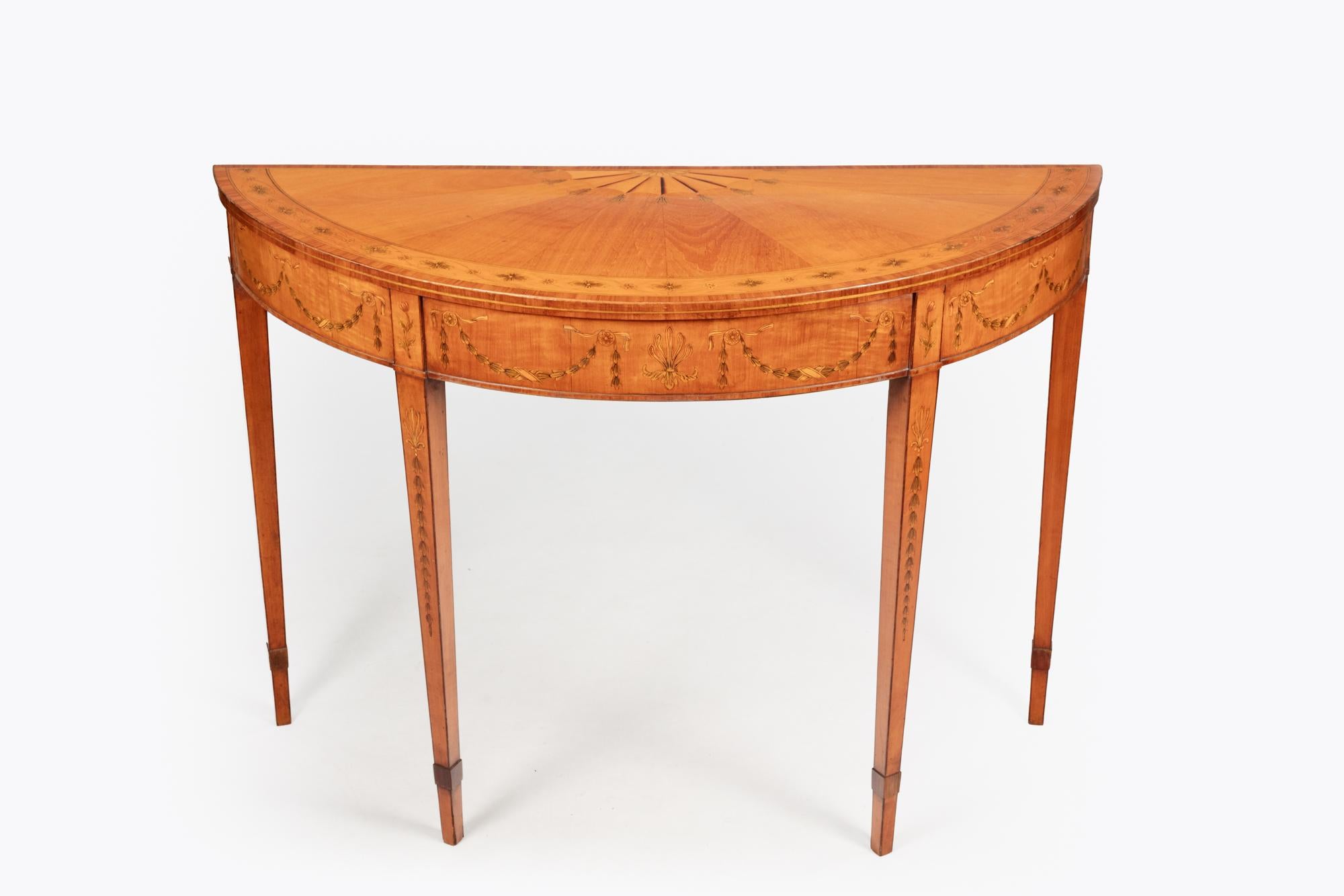 George III pair of satinwood and fruitwood marquetry demi lune tables the top with radiating veneers and an eliptical border centred by a fan motif.
In the style of William Moore of Dublin. Circa 1810.