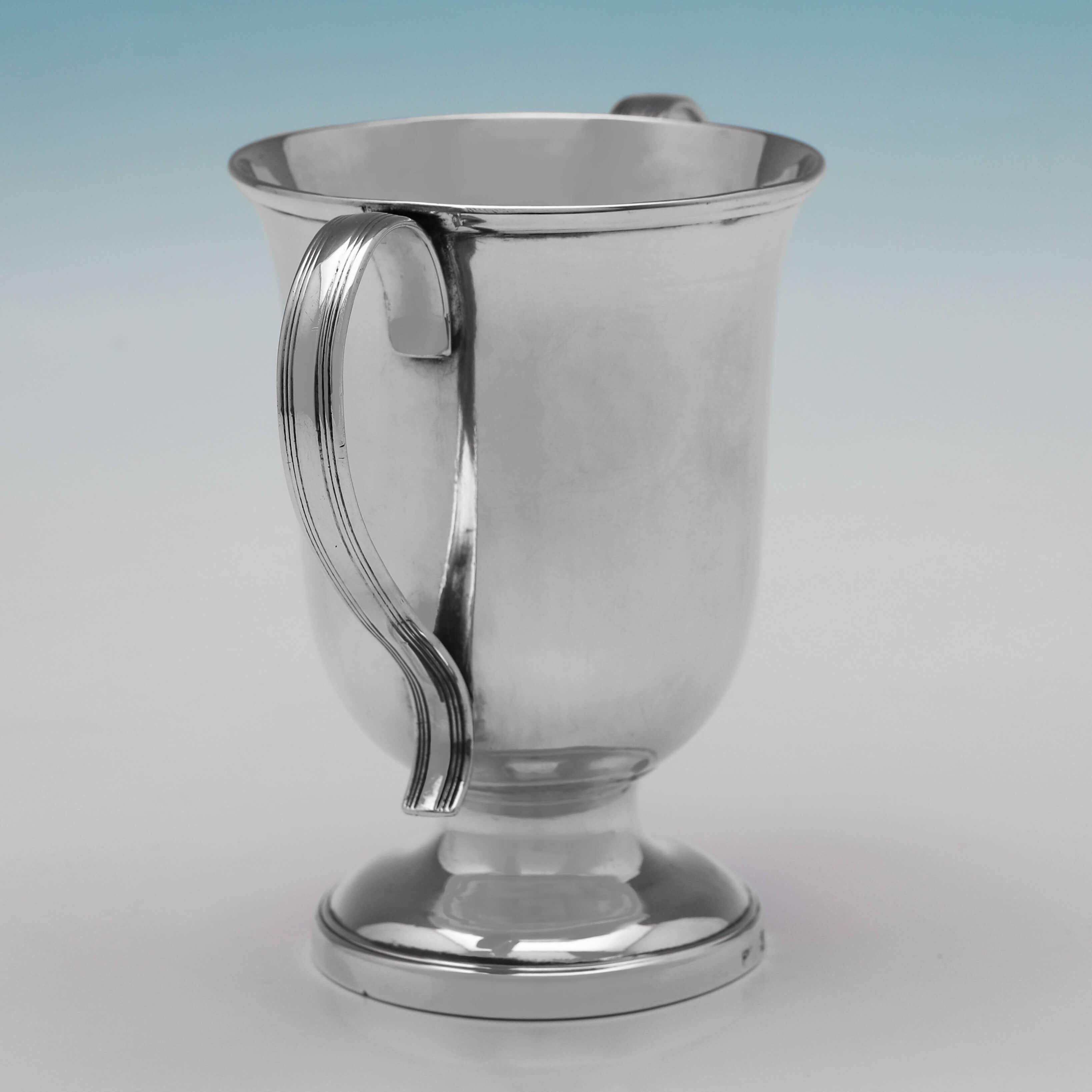 Hallmarked in Sheffield in 1803 by Eadon, Kibbles & Weaver, this this handsome, George III, Antique Sterling Silver Cup, is plain in style, and features two reed bordered loop handles, and a pedestal foot. 

The cup measures 4.5