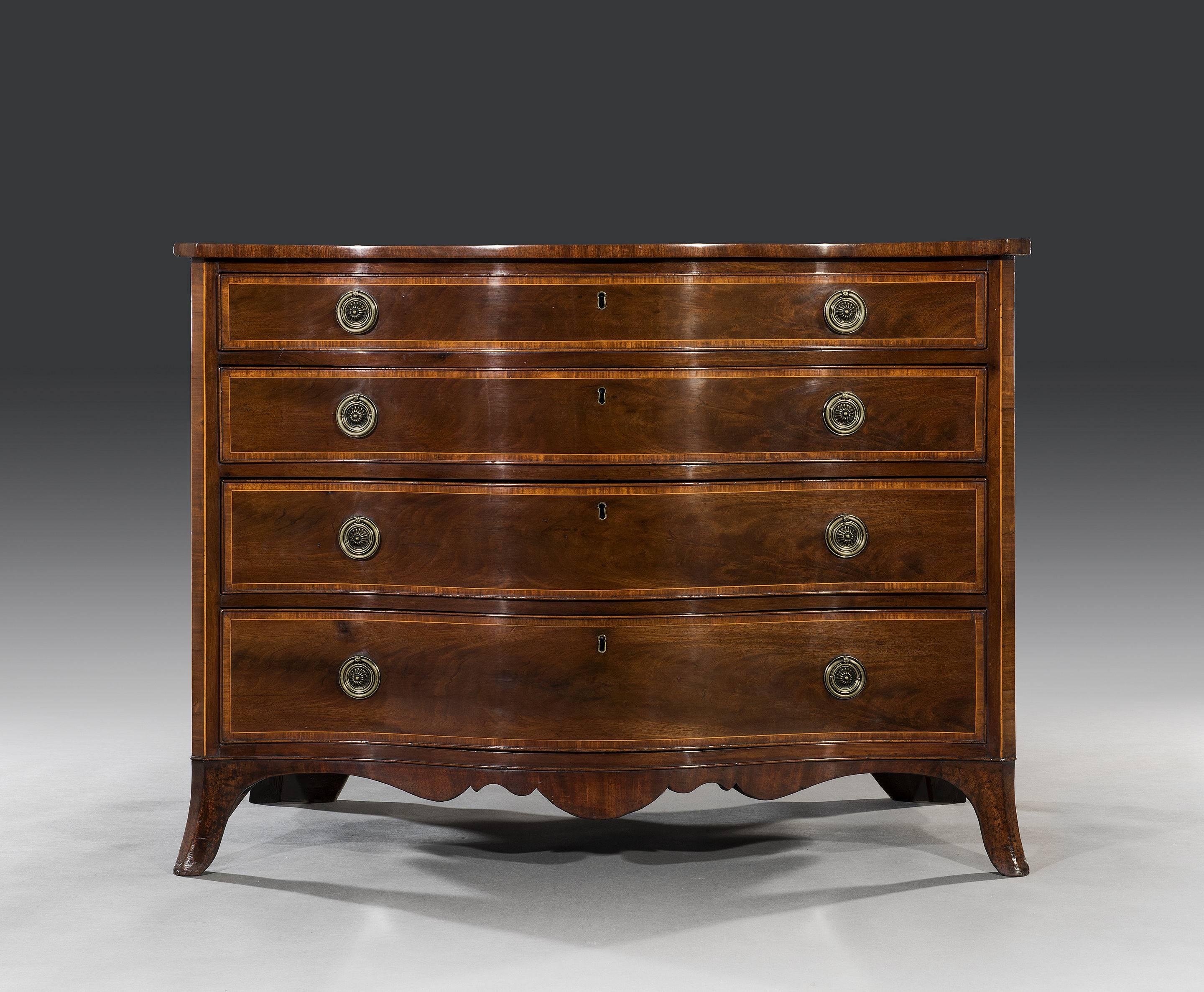 The mahogany serpentine shaped top is cross banded with kingwood and boxwood stringing with the top drawer being fitted with the original brushing slide. The four long graduated drawers that are oak lined and fitted with the original gilt-brass ring