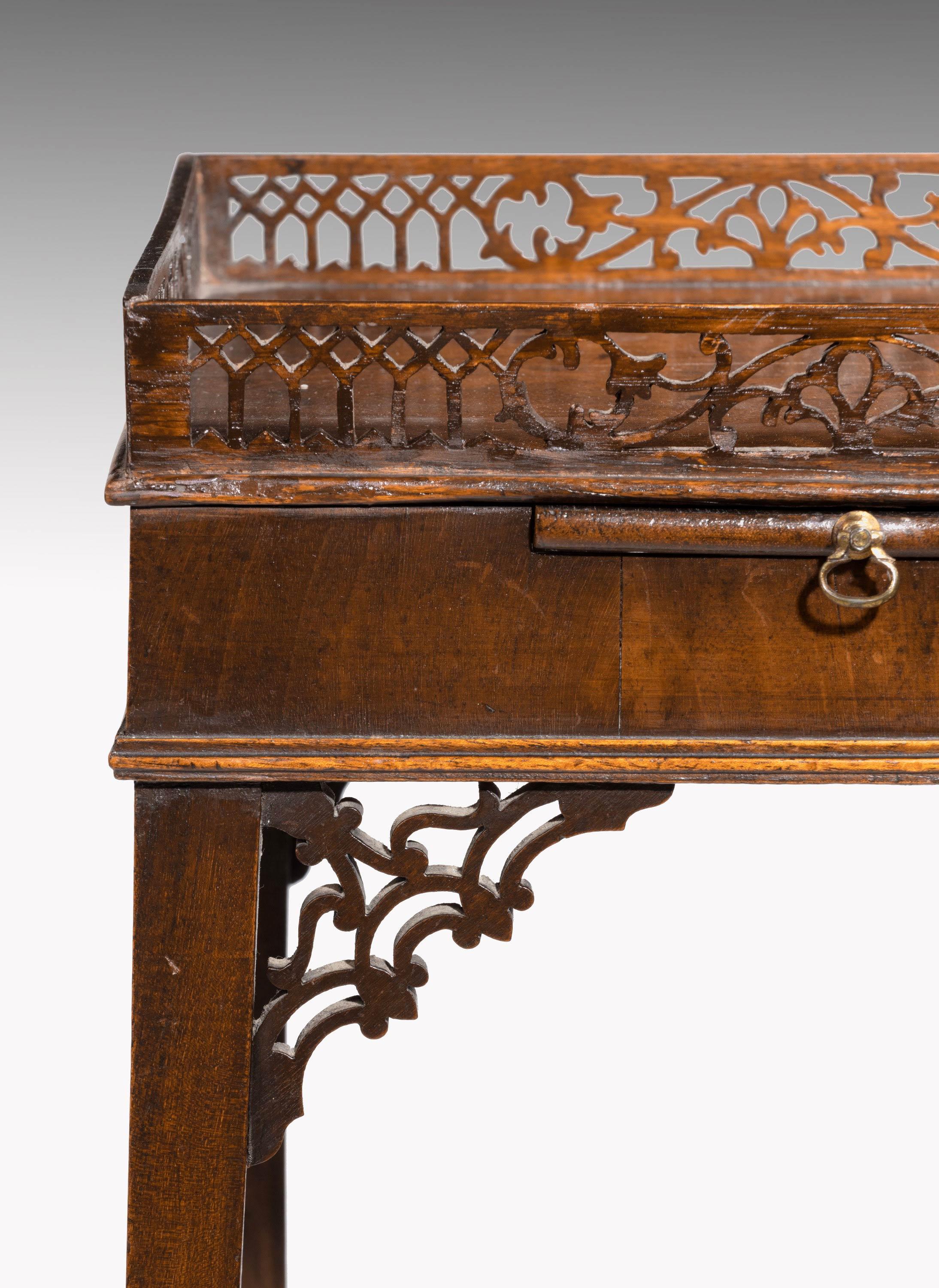 A George III period mahogany kettle stand in the Chippendale manner. With a well executed fretwork top and corner blocks incorporating a small slide. With original axe head knob.
   