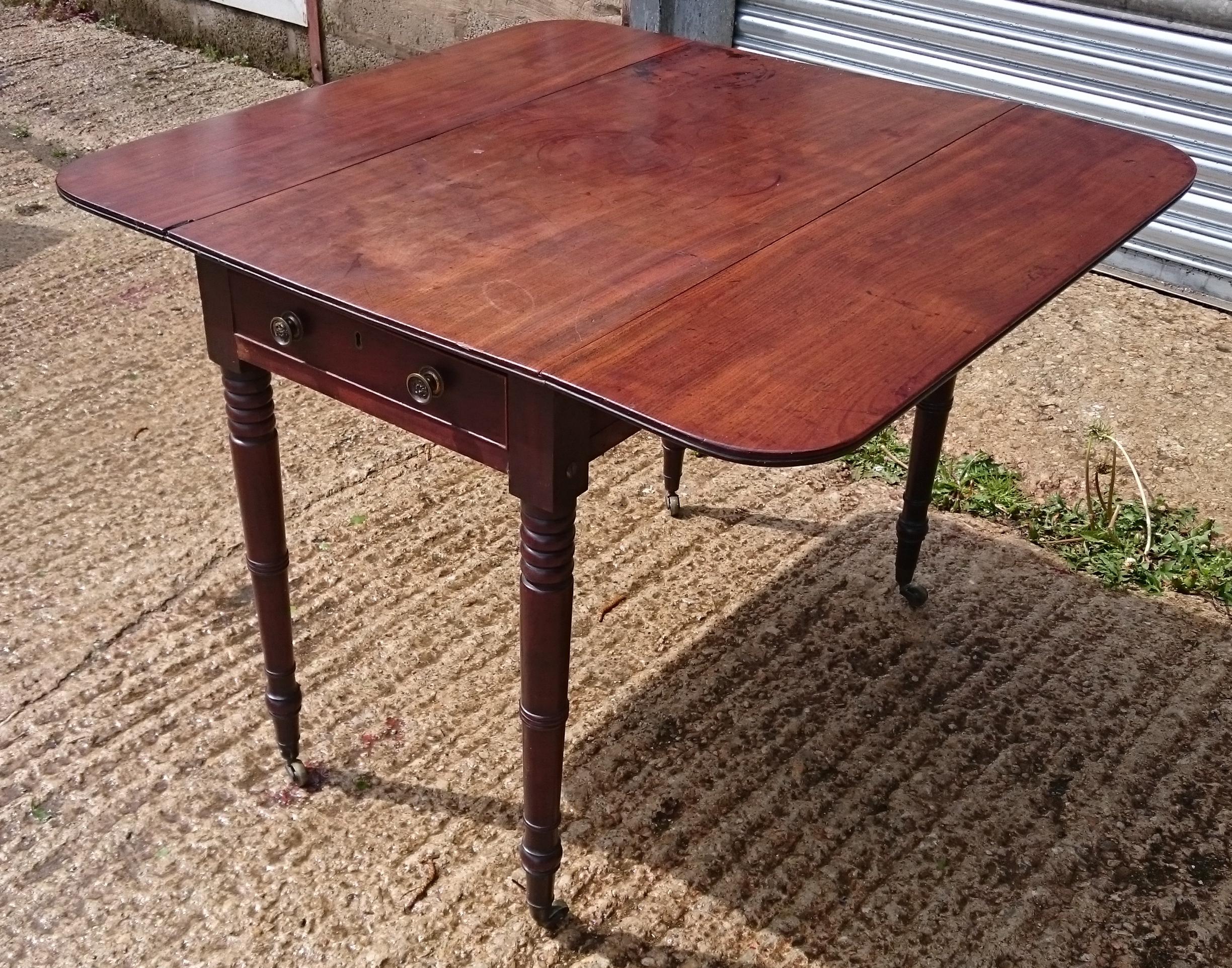 Charming little George III period mahogany antique Pembroke table. This table is very nicely made, with reeding around the edge of the top, elegant turned legs, thin frieze, double loper supports, one real and one dummy drawer, mahogany drawer