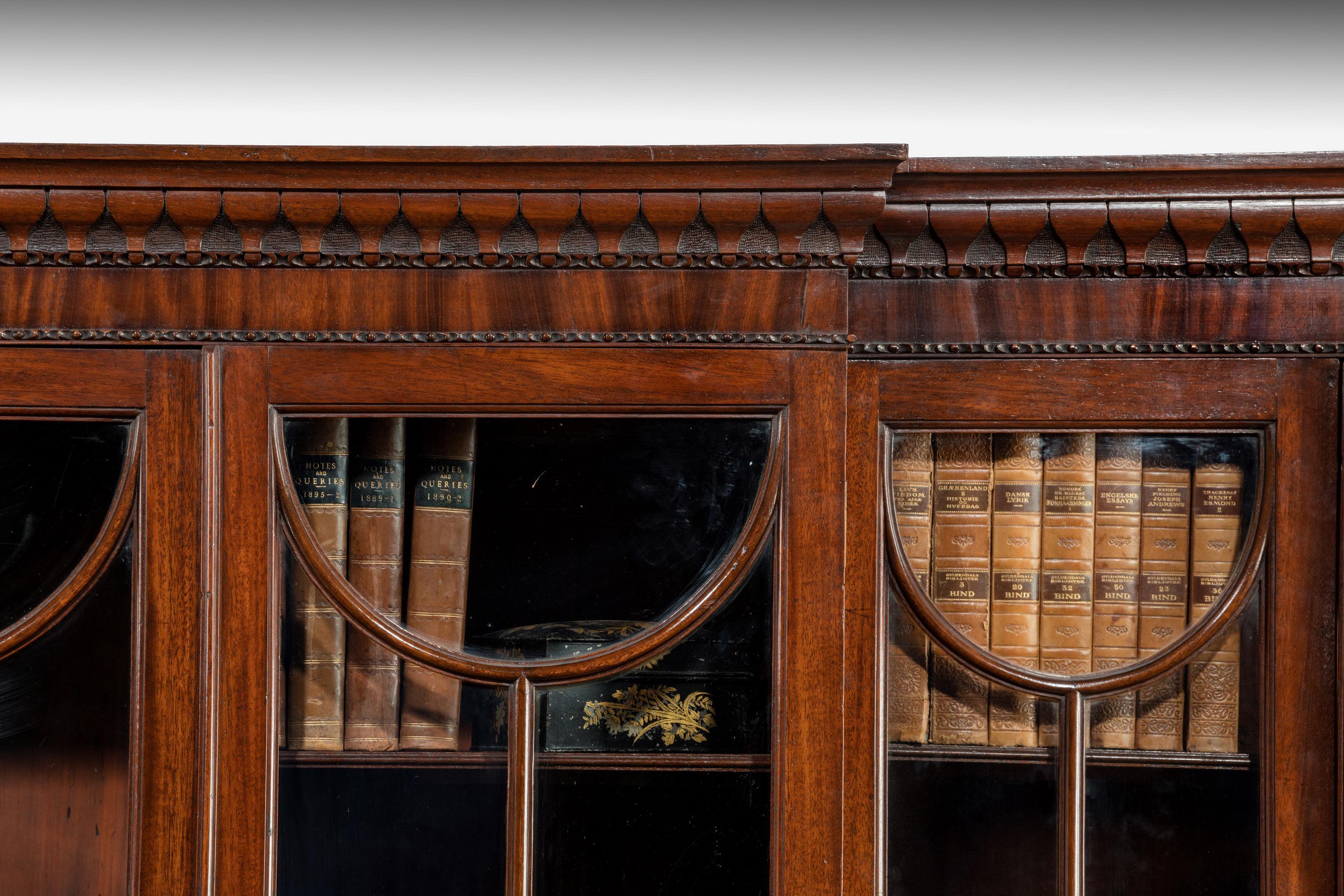 A fine quality late George III period mahogany double breakfront bookcase of unusual and well defined form. The eight drawers with moulded decoration and four terminals to the corners. The top very well designed with mahogany astragals. Good carved