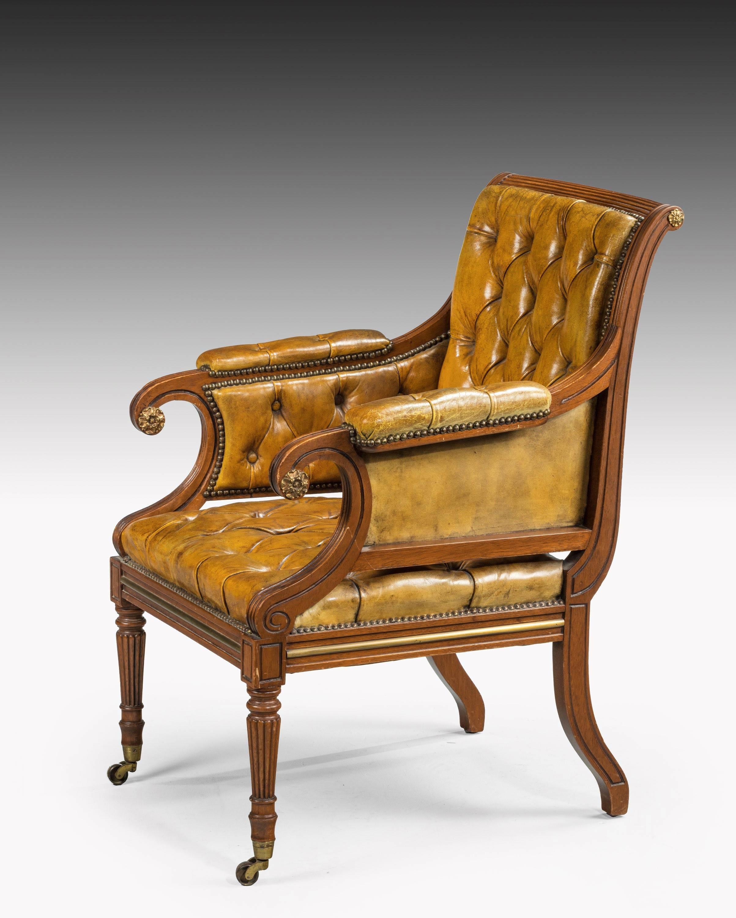 A fine quality, late George III period, mahogany framed library bergere chair. The frame with continuous reeded carving. Tapering circular supports, also with reeded carving. An old, but not original, deep buttoned leather cover, now finely matured.