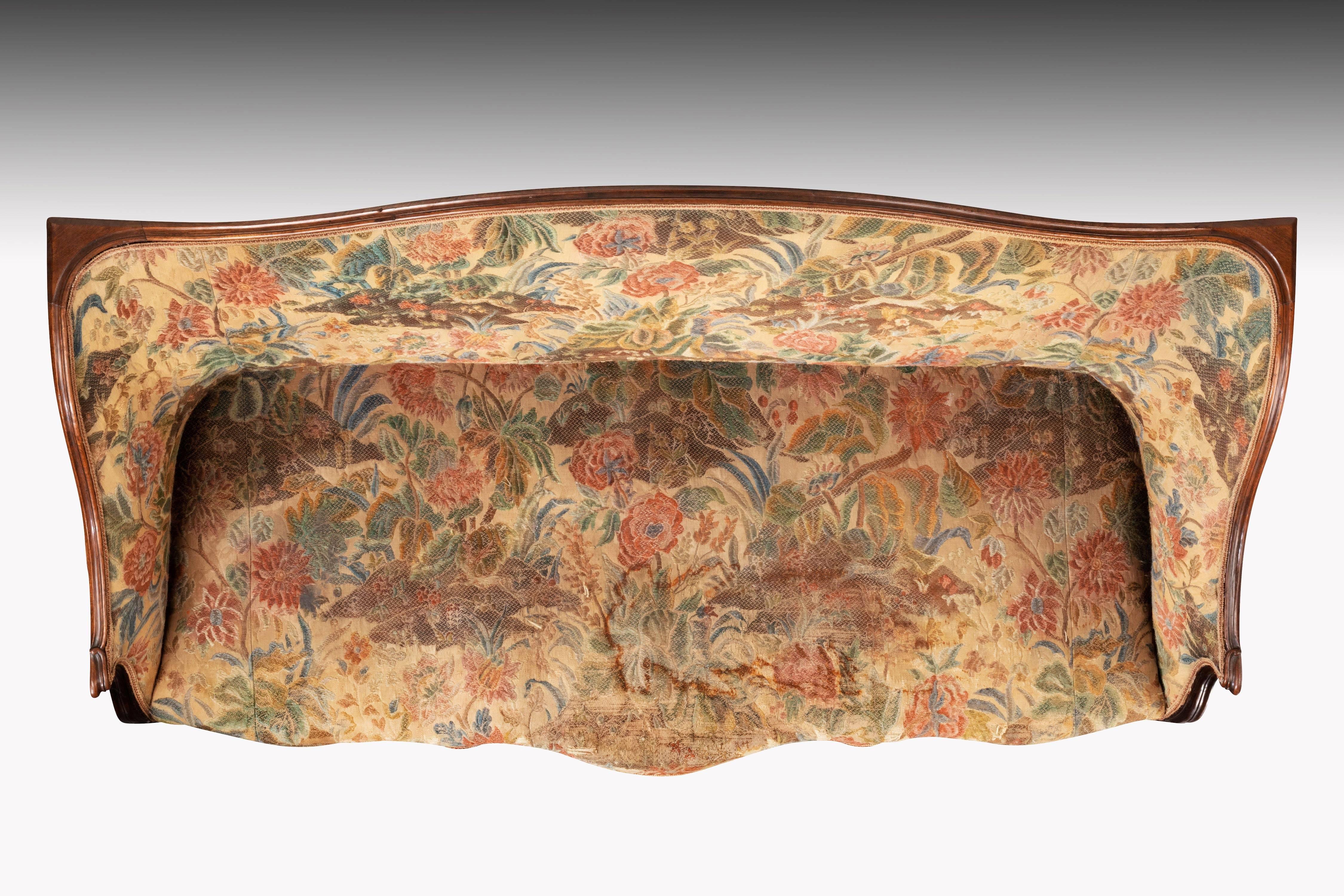 An elegant and most unusual mahogany framed George III period sofa. Overall convoluted shape with a triple serpentine front on French type supports. Retaining period tapestry, now somewhat worn at the front of the seat. This could possibly be
