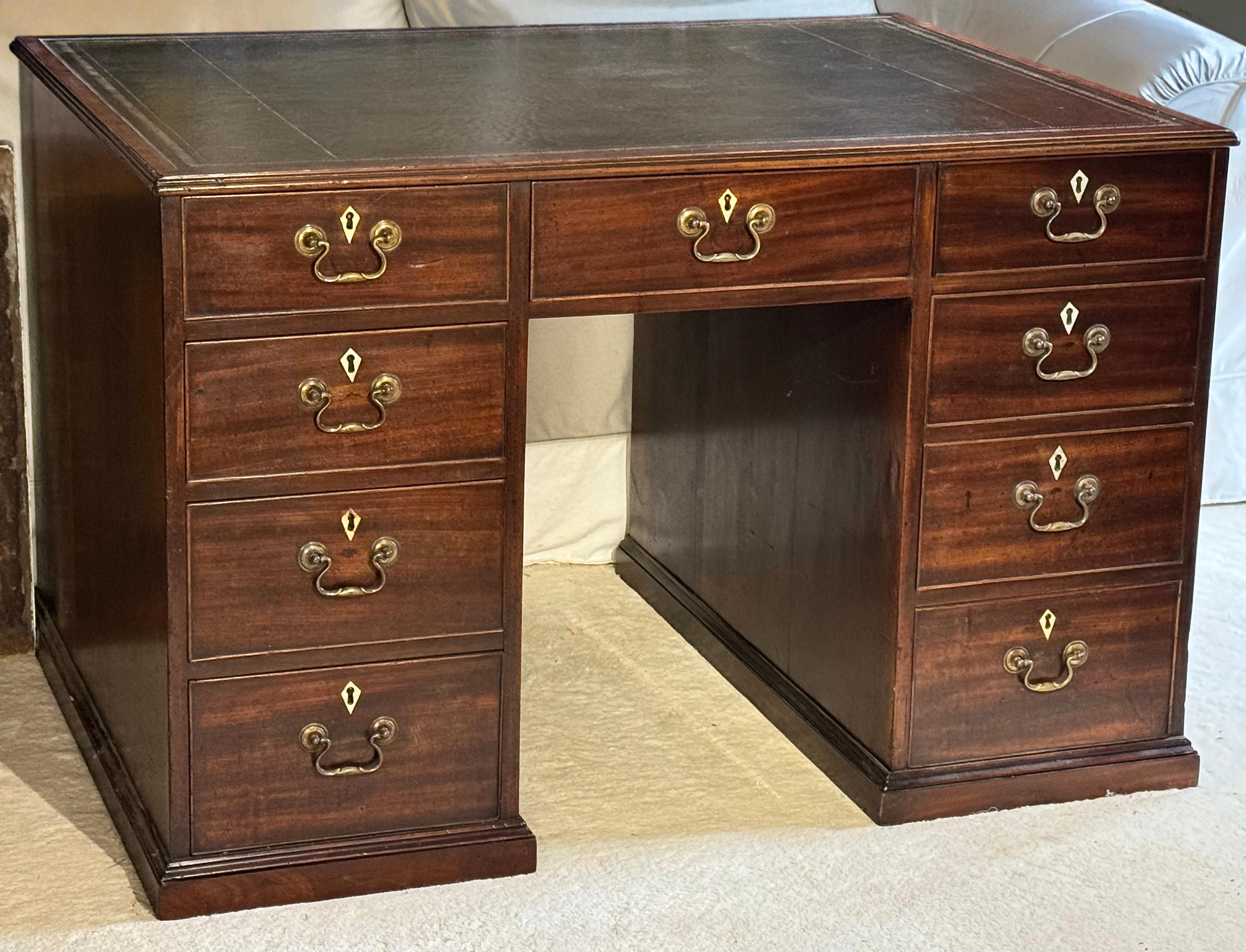 A fine George III-period mahogany partner’s desk, circa 1800.

This is a very good quality Georgian English partner’s desk of classic proportions.
Excellent deep, rich color and patination throughout.

Later beautifully fitted gilt-tooled green
