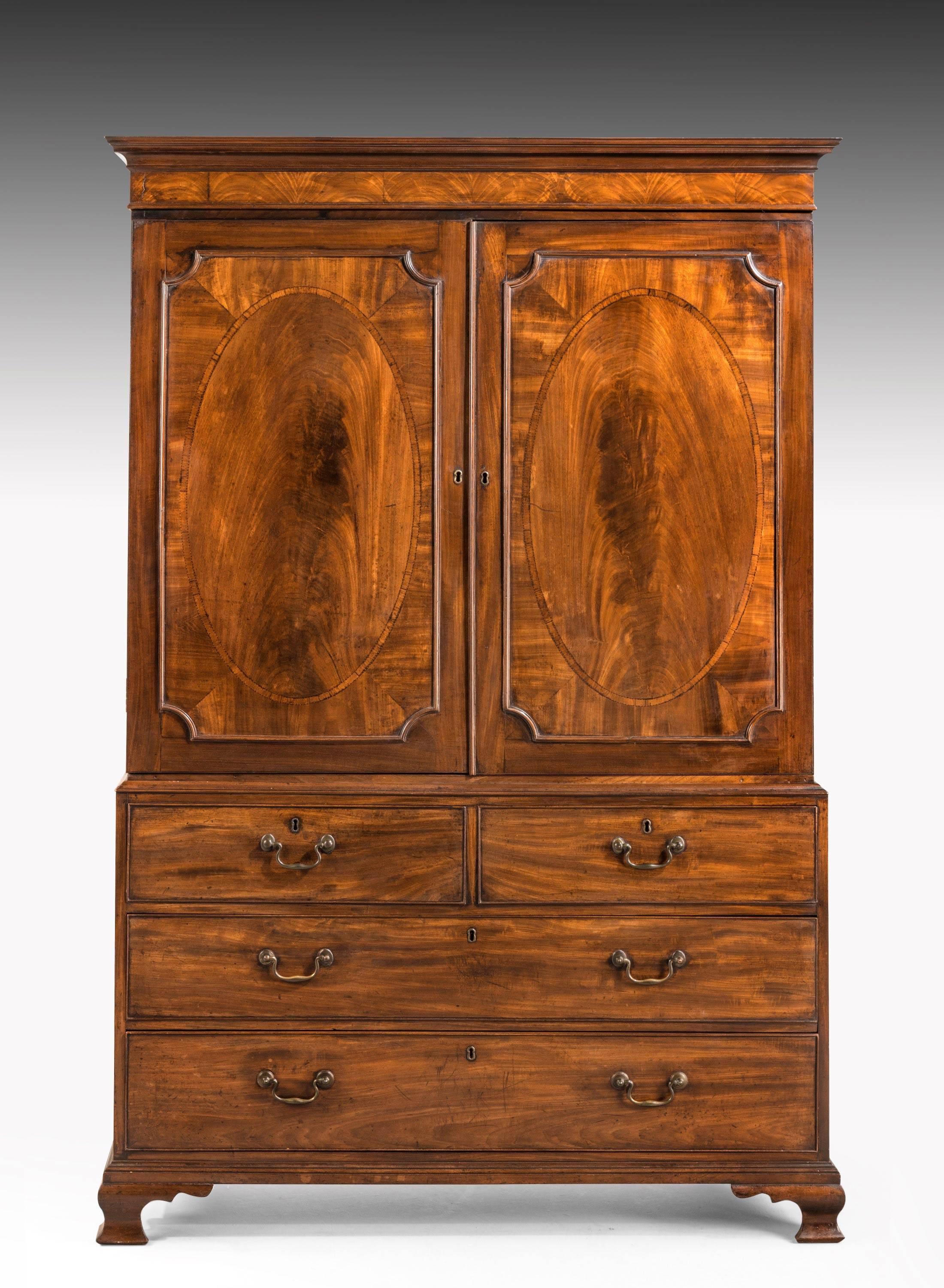 A very good George III period mahogany press. The interior now for hanging clothes. The oval panels doors of left and right hand flamed timbers, within quartered outer frames. Exceptional overall condition and colour. Obviously from a very good