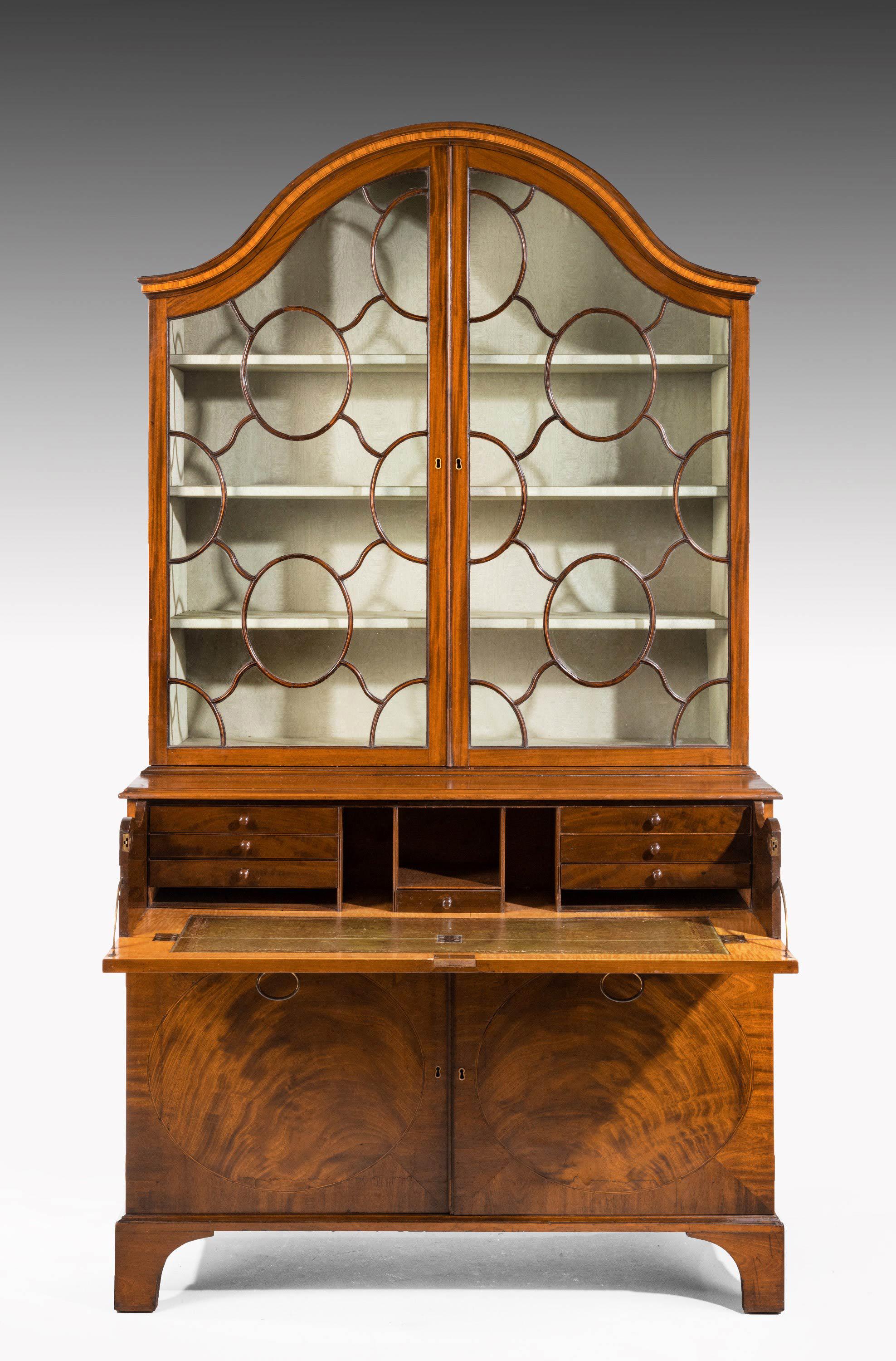 A most unusual George III period mahogany secretaire bookcase. The domed top with beautifully formed astrals involving oval and contrasting panels. The interior with pigeon holes, drawers and an inset leather top. The base with enclosing two doors