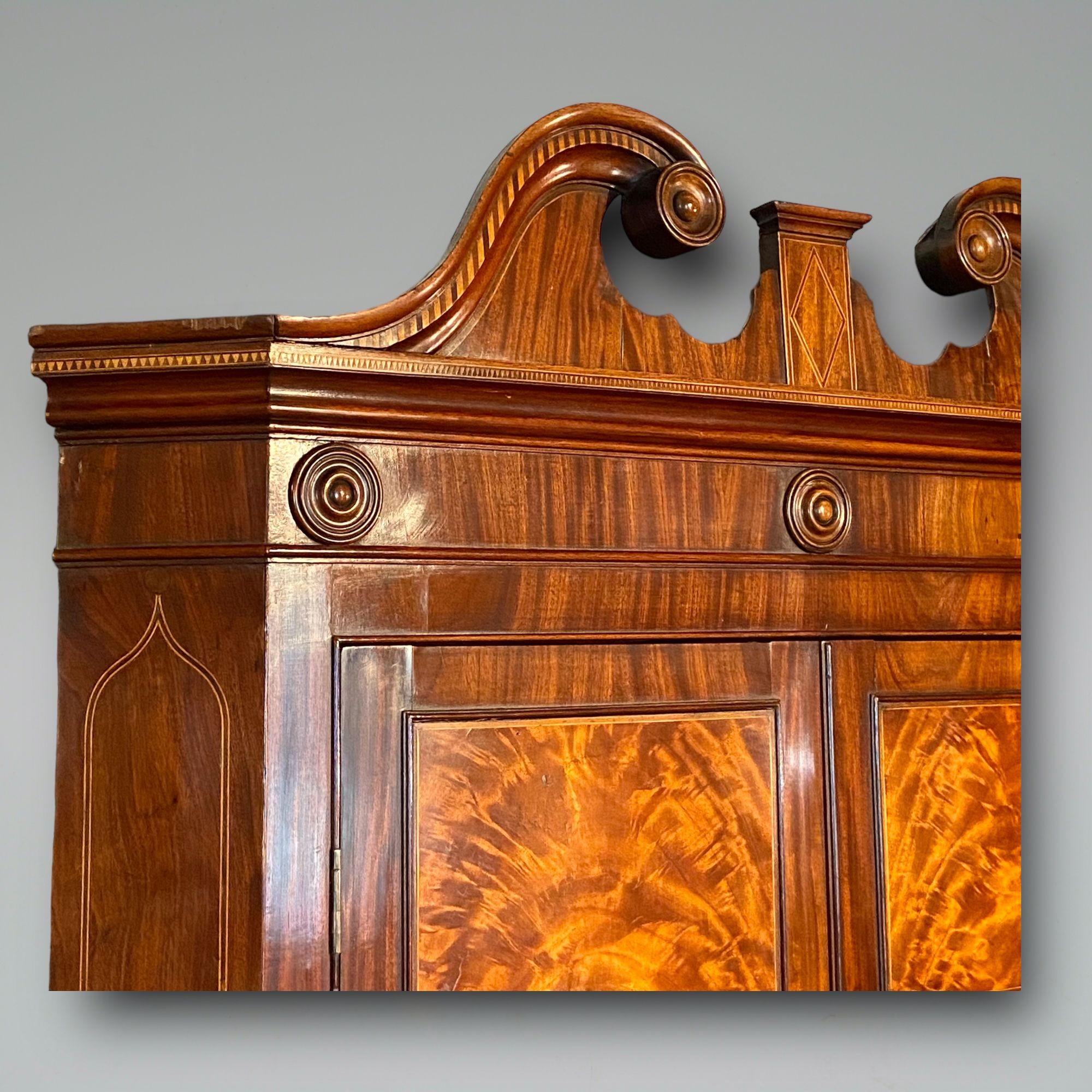 A fine example of a late 18th century floor standing mahogany corner cupboard with flame mahogany panels and swanneck pediment.