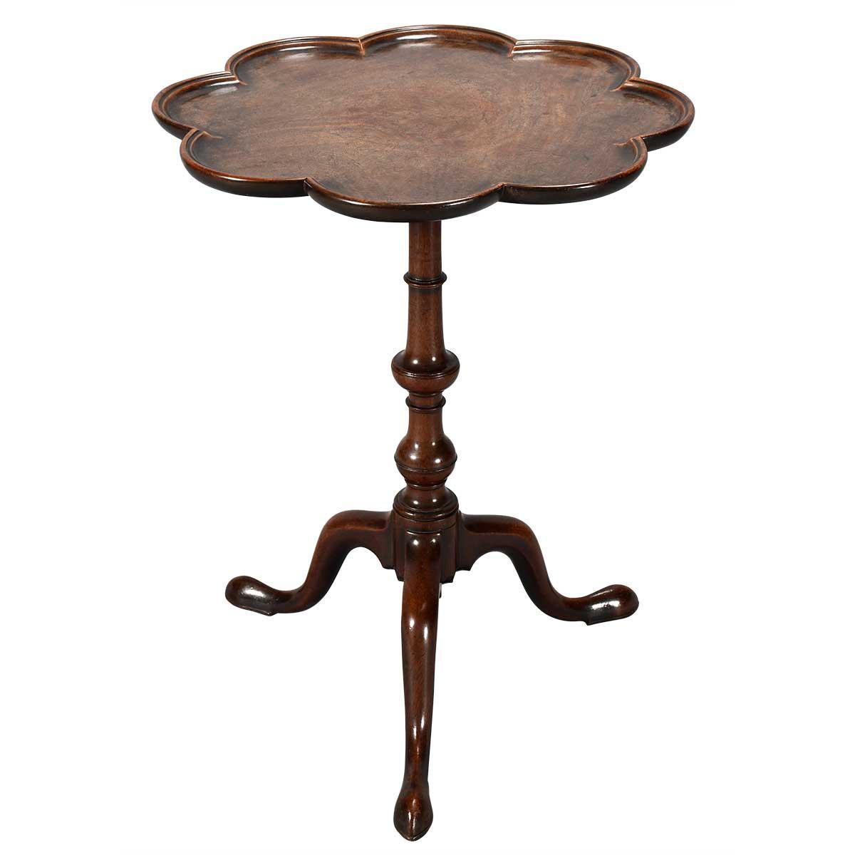 A fine quality mahogany tripod table on well-turned stem raised on elegantly shaped legs ending in slipper feet. The scallop-shaped top has a dished and beautifully molded edge and retains a fabulous color and patina. The darker area in the center