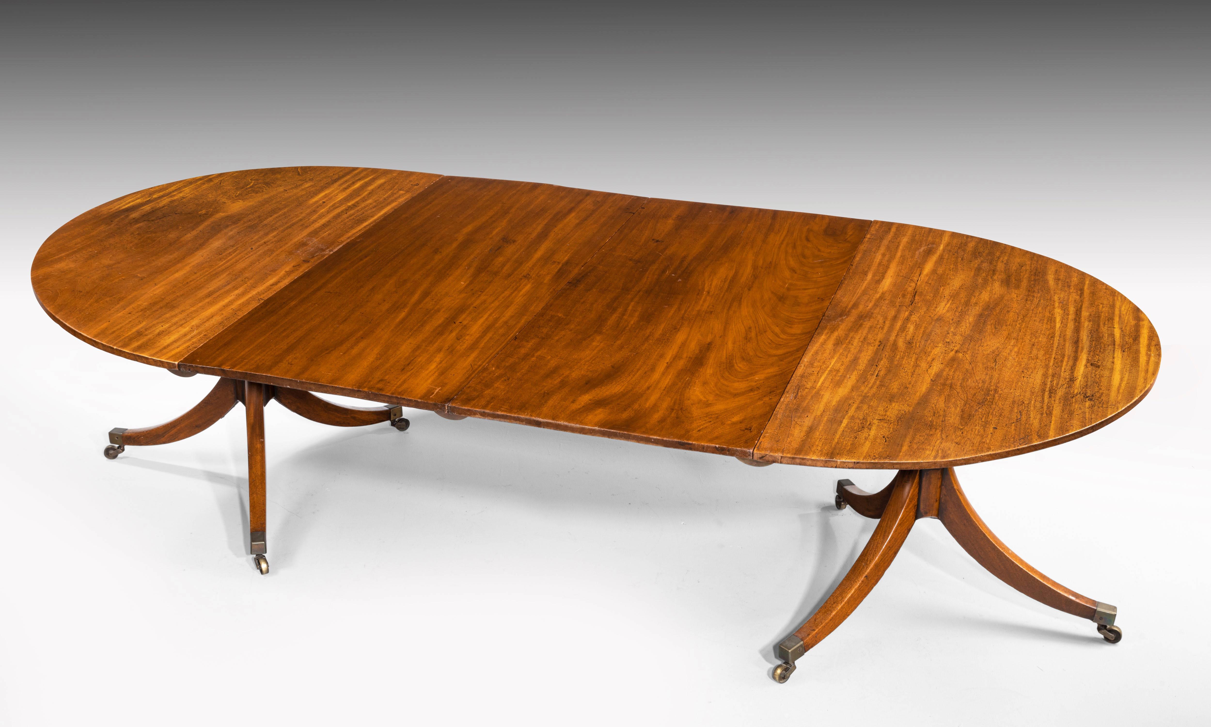 An attractive George III mahogany two pillar dining table with circular ends. Retaining the original shoes and castors. Two extra leaves with bearers can be used in various formats.